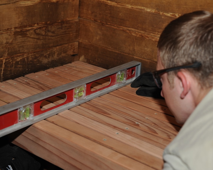 Staff Sgt. Shawn Spradlin, 2nd Civil Engineer Squadron Structures section, looks at a leveling device to ensure a sauna bench was installed straight at the Senior Airman Bryan R. Bell Fitness Center on Barksdale Air Force Base, La., April 29, 2014. A level tells a builder whether an object sits at a straight, sloped or vertical position. A level is an essential tool for builders because it enables them to position objects accurately. (U.S. Air Force photo/Senior Airman Benjamin Gonsier)