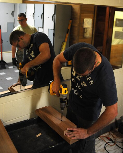 Brad Kolafa, 2nd Civil Engineer Squadron Structures section, drills two pieces of wood together to create a stable stand for a compound miter saw at the Senior Airman Bryan R. Bell Fitness Center on Barksdale Air Force Base, La., April 29, 2014. The structures section accomplishes more than 10,000 jobs a year.  (U. S. Air Force photo/Senior Airman Benjamin Gonsier)