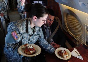 Sgt. Nicole Kanyer serves a passenger in a United States Army Priority Air Transport training flight to Puerto Rico, March 12, 2014. Kanyers, a steward with USAPAT is responsible for servicing customers in-flight needs, preparing and serving meals. (U.S. Air Force photo/Airman 1st Class Aaron Stout)