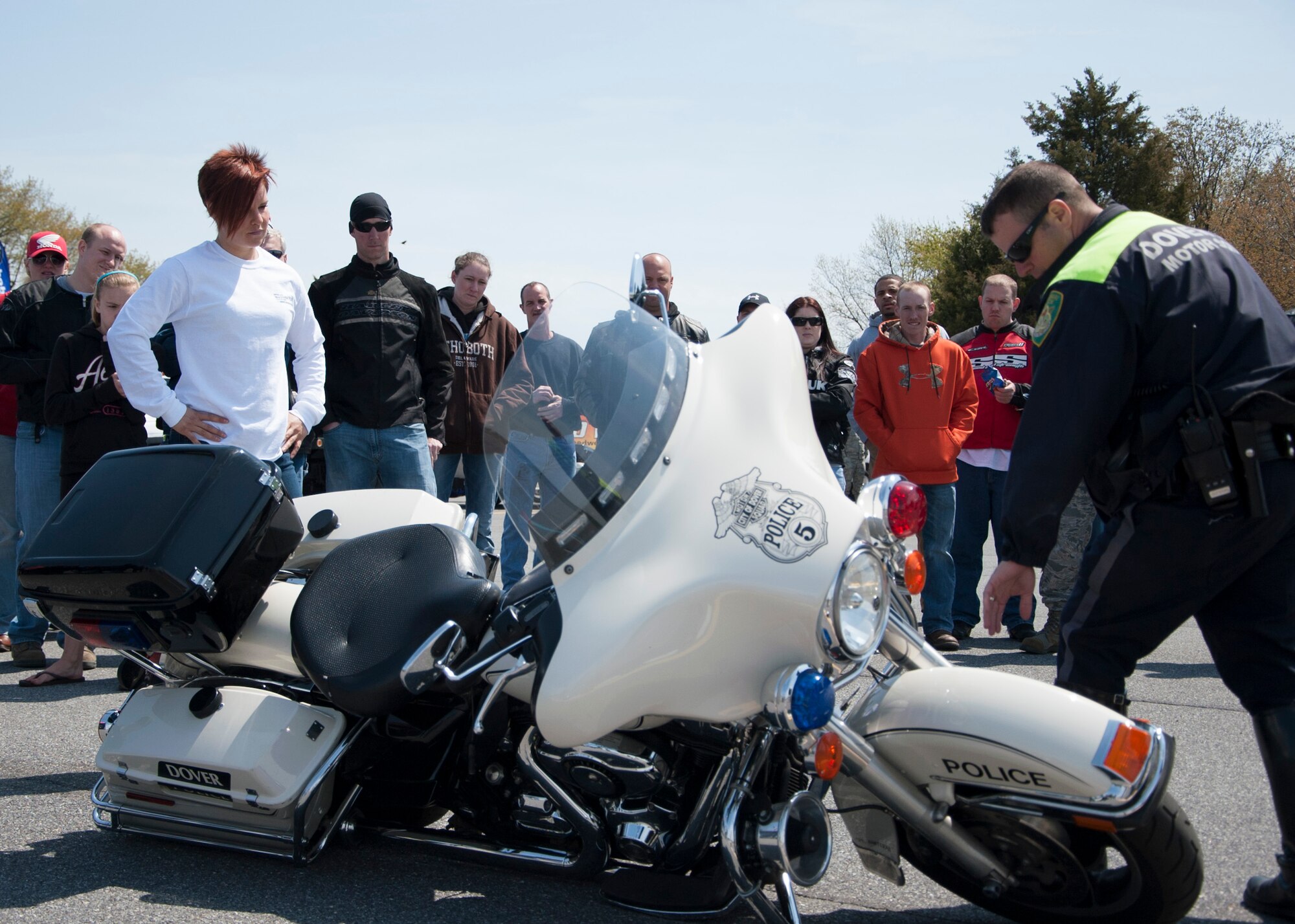 Cpl. Mark Guiteras, Dover Police Department special enforcement unit motorcycle officer, talks about how to properly lift a motorcycle up after a drop during Motorcycle Safety Day April 25, 2014, on Dover Air Force Base, Del.  Dover PD later demonstrated the agility of their large motorcycle. (U.S. Air Force photo/Senior Airman Jared Duhon)