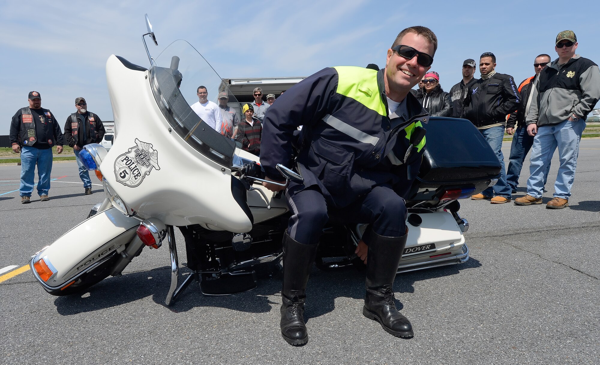 Cpl. Mark Guiteras, Dover Police Department Special Enforcement Unit, demonstrates how to lift heavy motorcycles safely to a crowd gathered during the Dover Air Force Base, Del. 2014 Motorcycle Safety Day, on April 25, 2014. The annual event reinforced messages about safe riding and operations along with Air Force and local base regulations. (U.S. Air Force photo/Greg L. Davis)