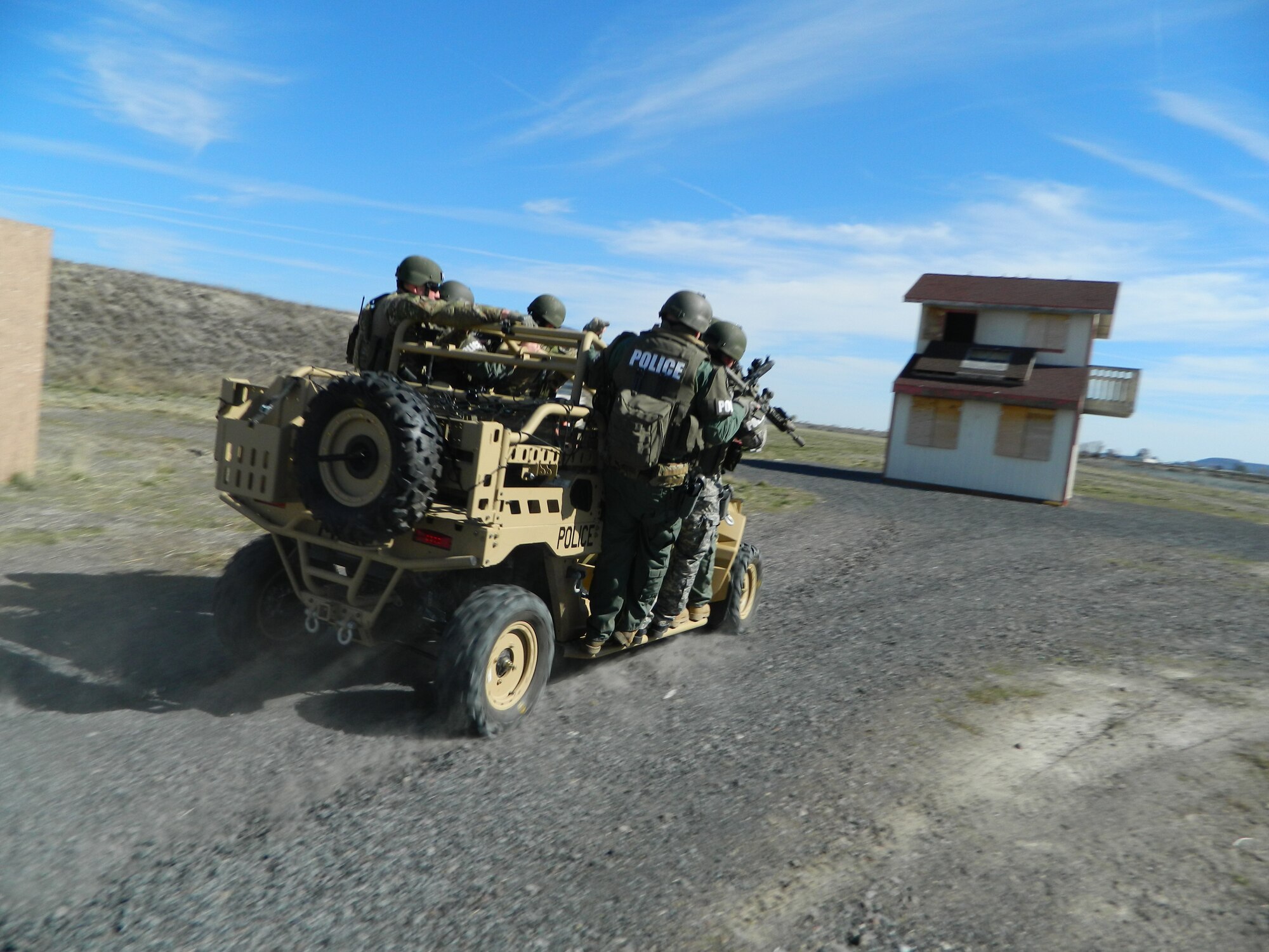 Members of Klamath Falls SWAT team catch a ride from a 173rd Security Forces vehicle driven by Master Sgt. Joshua Hilton as they practice their urban assault techniques here at Kingsley Field, March 19, 2014. (U.S. Air National Guard photo by 2nd Lt. Adrian Mateos).