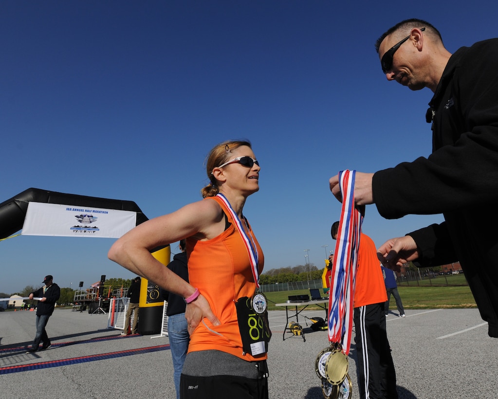 Chief Warrant Officer 4 Deanna Merriman, Defense Intelligent Agency Joint Military Attaché School instructor, receives a medal moments after crossing the finish line. She earned first place for the female runner during the Joint Base Andrews Half Marathon here April 26, 2014. Merriman, an avid runner, participated in her first Boston Marathon just five days prior to competing in Saturday’s race. (U.S. Air Force photo/Senior Airman Nesha Humes)

