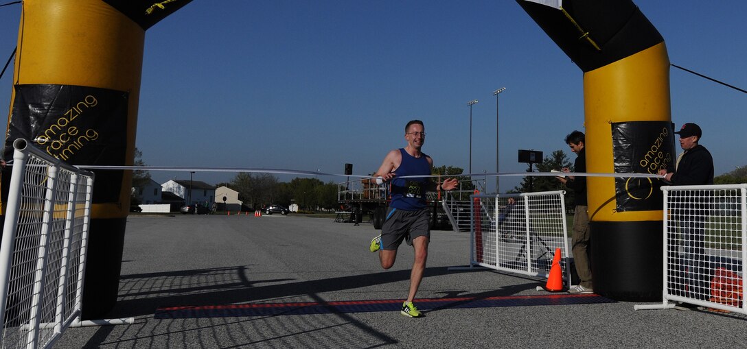 Capt. Phil Blong, 29th Intelligence Squadron operations engineer, crosses the finish line first during the Joint Base Andrews Half Marathon on JBA, Md., April 26, 2014. Blong was the first place finisher with a run time of 1:20:41. (U.S. Air Force photo/Senior Airman Nesha Humes)
