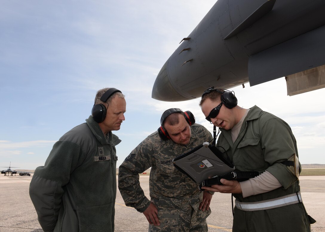 Master Sgt. Stephen Murray, (left) Air Combat Command Inspector General team member, reviews the capability of Tech. Sgt. Ronald Studer, 28th Maintenance Group quality assurance chief inspector, and Tech. Sgt. Scott Daley, 28th Aircraft Maintenance Squadron crew chief, to assess a technical order during a hot pit refueling activity on the flightline at Ellsworth Air Force Base, S.D. April 15, 2014. The process was one of several areas evaluated during the ACC/IG Unit Effectiveness Inspection April 13 to 18. (U.S. Air Force photo by Airman 1st Class Rebecca Imwalle/ released)