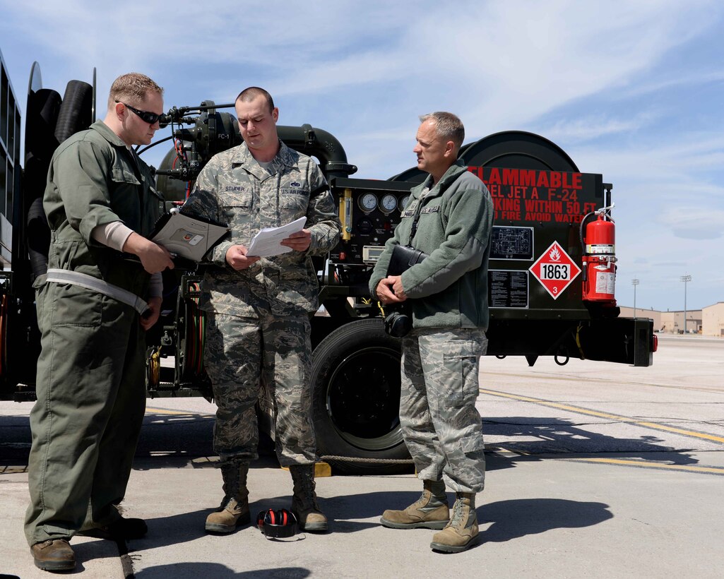 Tech. Sgt. Scott Daley, (left) 28th Aircraft Maintenance Squadron crew chief, is briefed on the new inspection process by Tech. Sgt. Ronald Studer, 28th Maintenance Group quality assurance chief inspector, as Master Sgt. Stephen Murray, Air Combat Command Inspector General team member, listens intently on the flightline at Ellsworth Air Force Base, S.D. April 15, 2014. Murray evaluated Studer’s ability to inspect Daley during a hot pit refueling activity as a part of an ACC/IG Unit Effectiveness Inspection April 13 to 18. (U.S. Air Force photo by Airman 1st Class Rebecca Imwalle/ released)