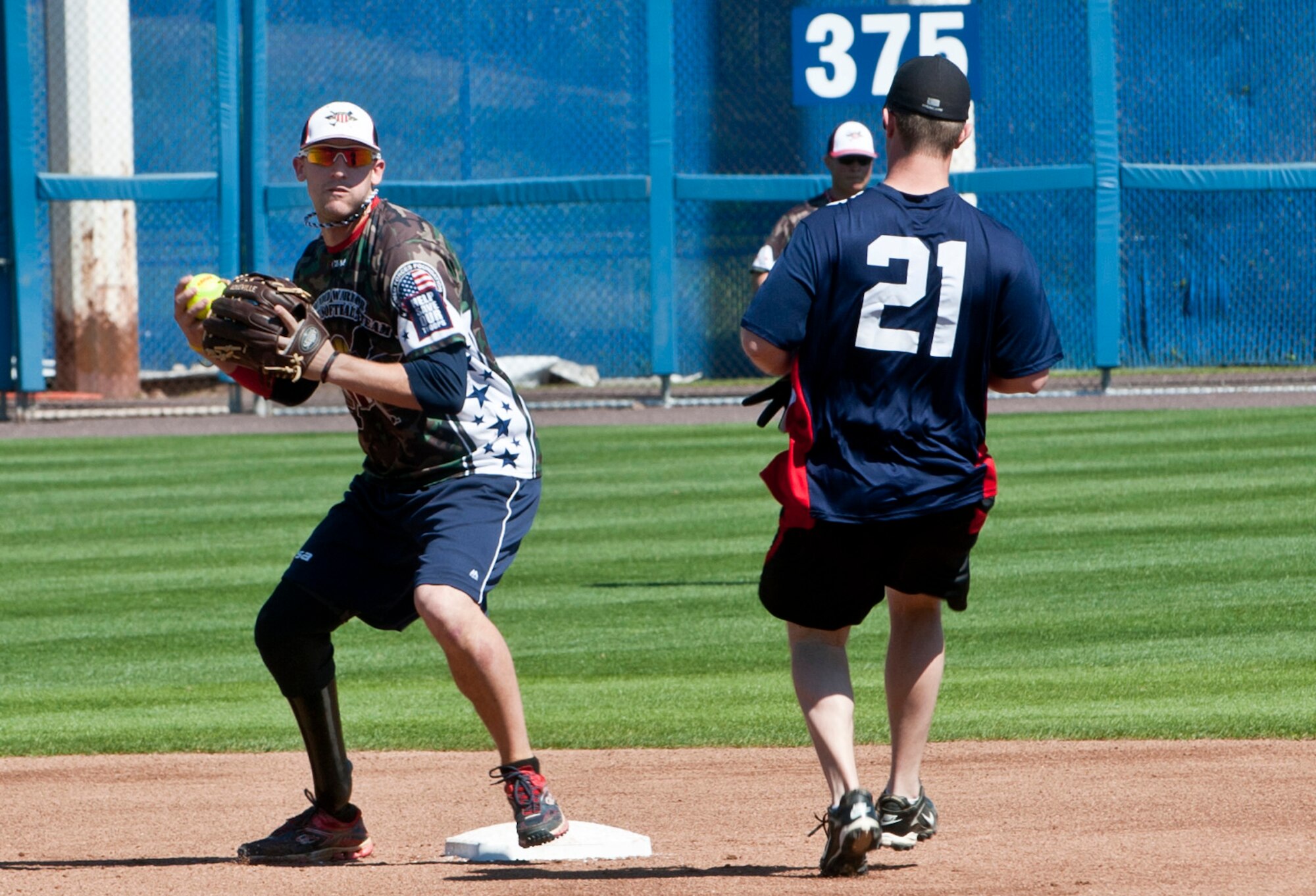 Matthew Kinsey, a U.S. Army veteran and Wound Warrior Amputee Softball team second baseman, throws the ball to first base during the 2nd annual Spartyka Wounded Warrior Softball Classic at Harbor Park in Norfolk, Va., April 26, 2014. The team is scheduled to continue their season in Mission Viejo, Calif., May 2. (U.S. Air Force photo by Senior Airman R. Alex Durbin/Released)