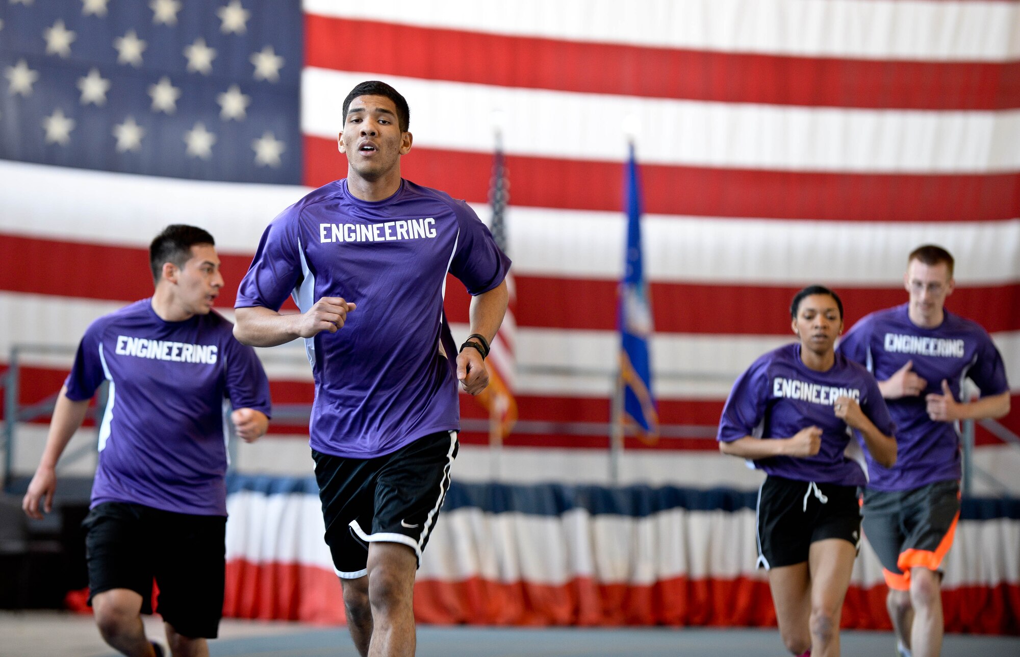 Airmen assigned to the 28th Civil Engineer Squadron run a lap in the Pride Hangar during the Sexual Assault Prevention Combat Challenge in the Pride Hangar at Ellsworth Air Force Base, S.D., April 24, 2014. The event was open to everyone with several team-based challenges, encouraging mental and physical resiliency for all competitors. (U.S. Air Force photo by Senior Airman Zachary Hada/Released)