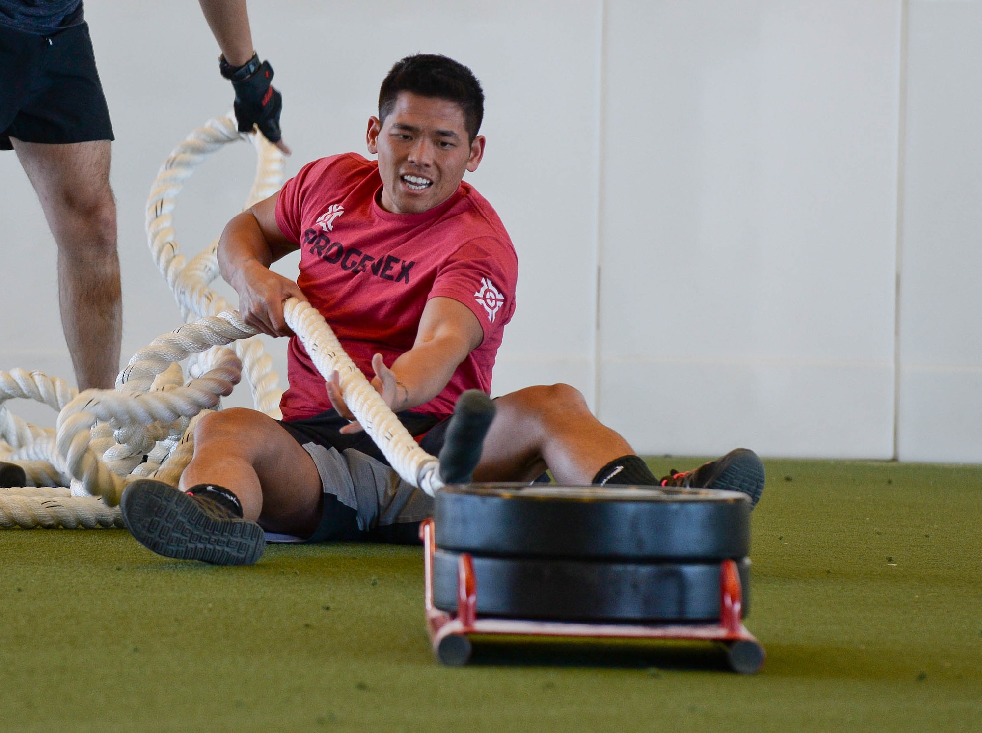 Staff Sgt. Otto Yan, 28th Security Forces Squadron military working dog handler, performs a weighted rope pull during the inaugural Sexual Assault Prevention Combat Challenge in the Pride Hangar at Ellsworth Air Force Base, S.D., April 24, 2014. The event consisted of team-based obstacles and was meant to raise awareness about sexual assault awareness and prevention month. (U.S. Air Force photo by Senior Airman Zachary Hada/Released)