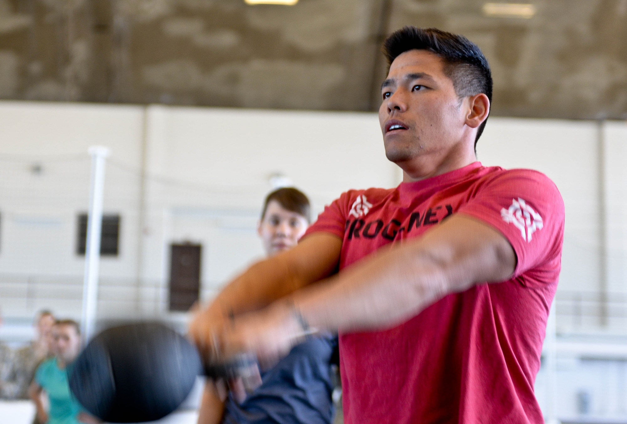 Staff Sgt. Otto Yan, 28th Security Forces Squadron military working dog handler, performs kettlebell raises during the Sexual Assault Prevention Combat Challenge in the Pride Hangar at Ellsworth Air Force Base, S.D., April 24, 2014. Twelve teams of four people competed in the event done as part of Sexual Assault Awareness and Prevention Month. (U.S. Air Force photo by Senior Airman Zachary Hada/Released)