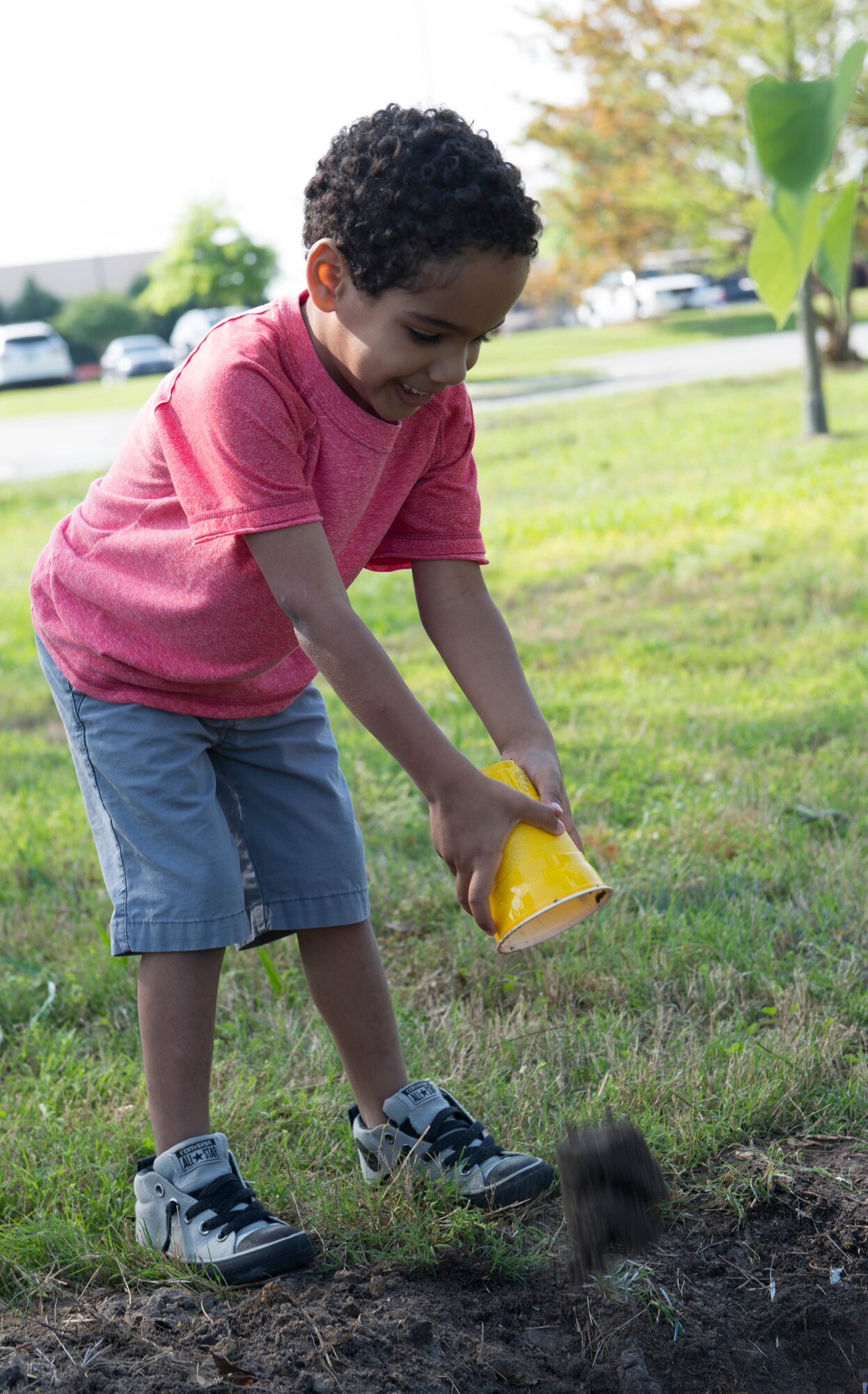 A child from the Child Development Center dumps potting soil at the base of a tree planted in honor of Earth Day and Arbor Day at Moody Air Force Base, Ga., April 25, 2014. Earth Day and Arbor Day are about bringing awareness to the importance of Earth’s plants by inspiring people to plant, nurture and celebrate trees. (U.S. Air Force photo by Airman Dillian Bamman/Released)