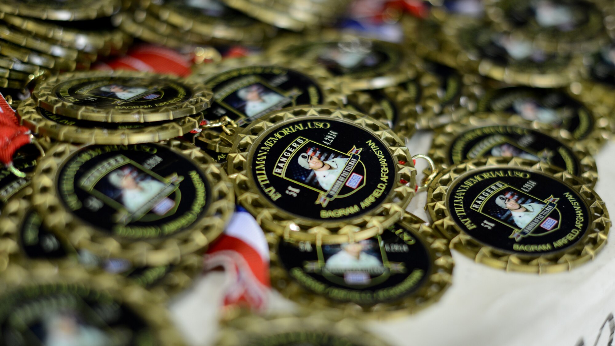 Medals for the 10th Annual Pat Tillman 5k run are displayed on a table at Bagram Airfield, Afghanistan April 29, 2014.  The annual race honors Pat Tillman, a former NFL player and Army Ranger who lost his life while serving in Afghanistan in 2004.  (U.S. Air Force photo by Staff Sgt. Evelyn Chavez/Released)