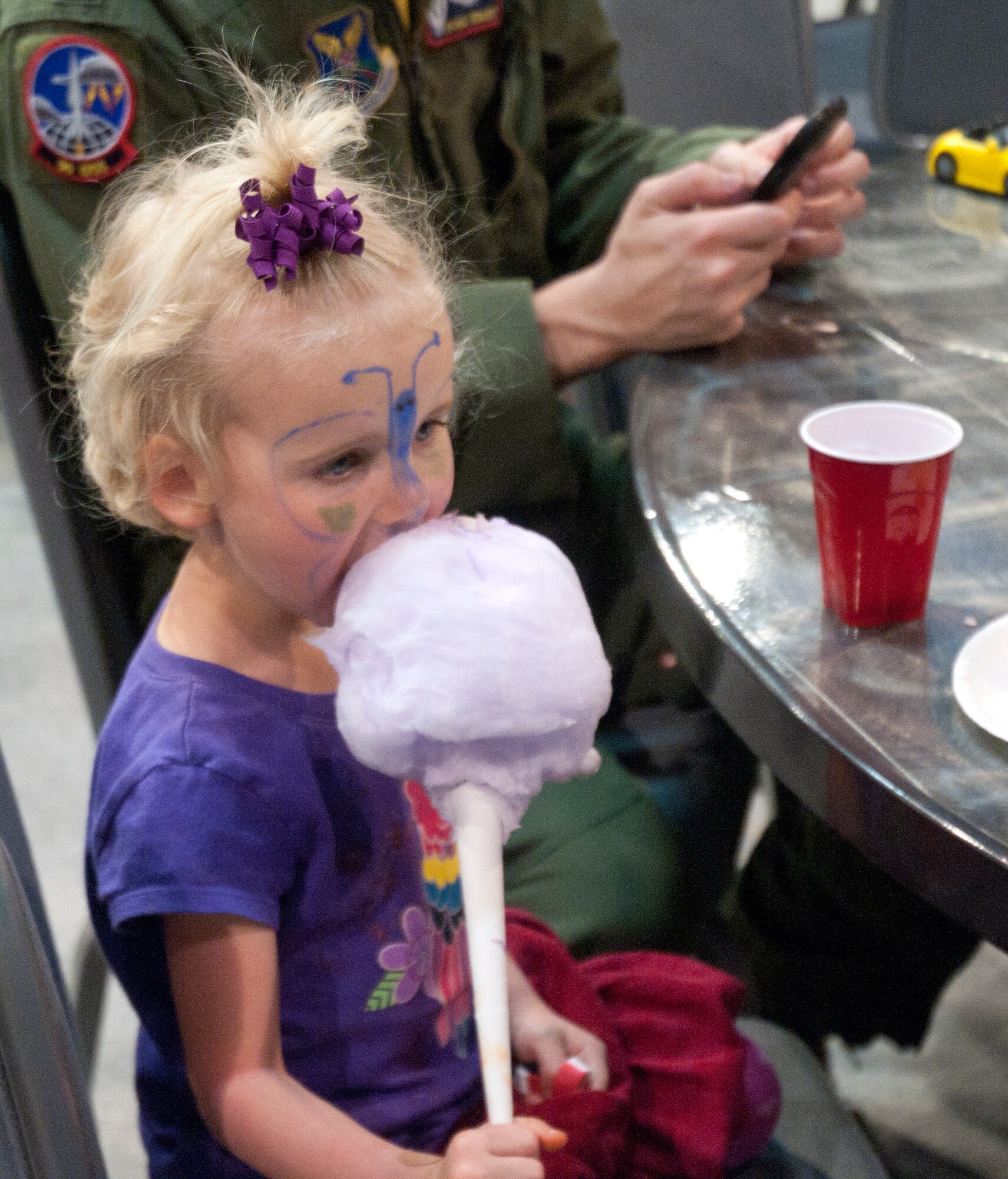 Carylise Douglas, 3, daughter of Capt. James Douglas, 321st Missile Squadron, eats cotton candy during the Military Child Bash April 25 in the Fall Hall Community Center. (U.S. Air Force photo by Airman Malcolm Mayfield)