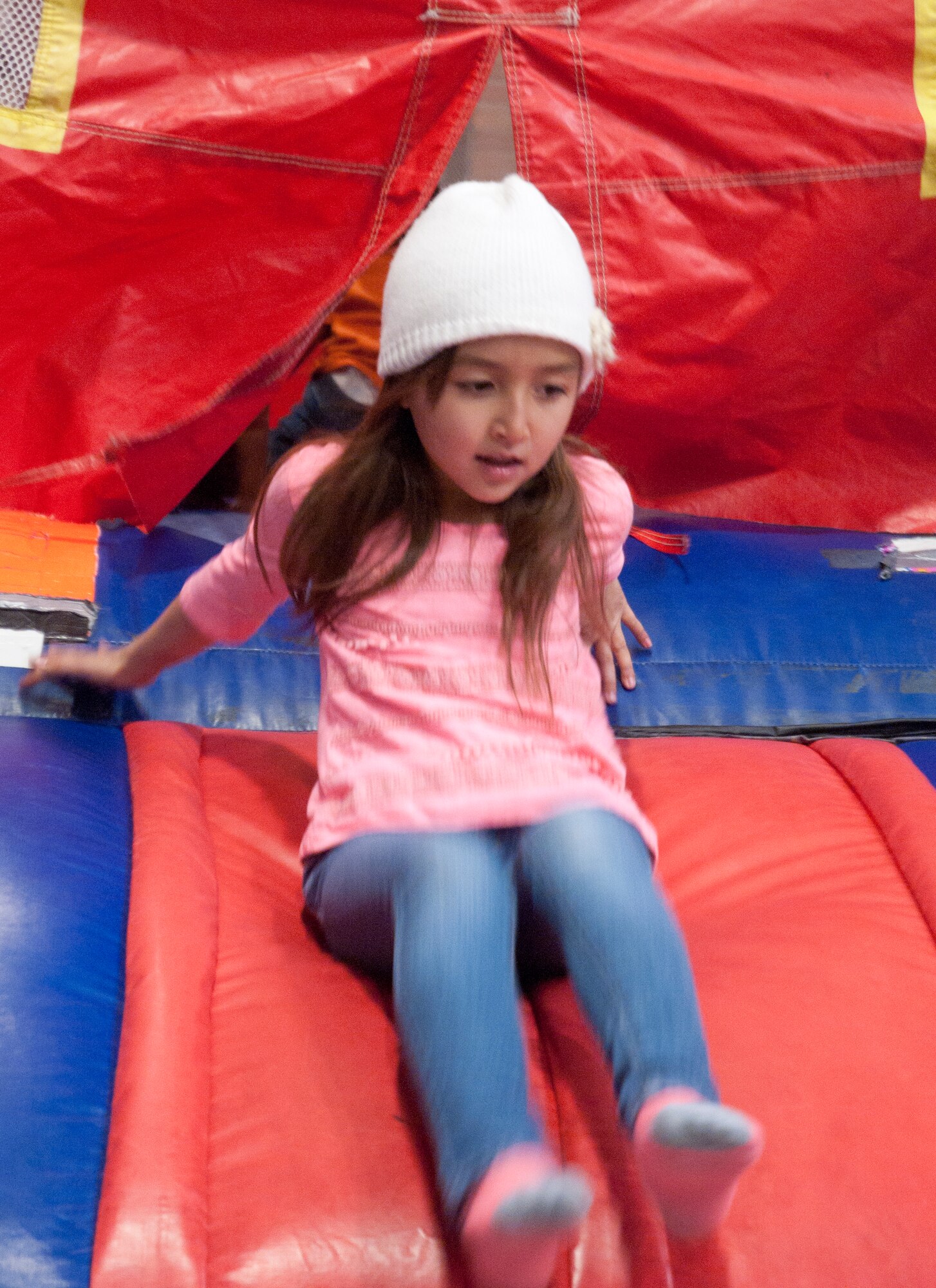 Angelina Varga, 7, daughter of Master Sgt. Adam Varga, 90th Logistics Readiness Squadron, exits a bouncy house April 25 in the Fall Hall Community Center. Children participated in carnival games, arts and crafts, a cake walk, face painting and bouncy houses during the Month of the Military child event. (U.S. Air Force photo by Airman Malcolm Mayfield)