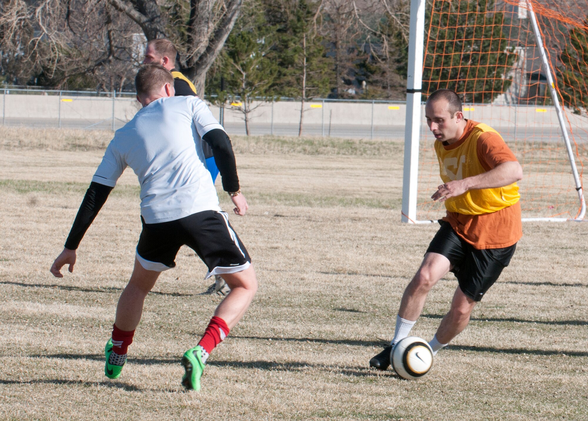 Daniel Weisz, 90th Medical Operations Squadron, moves the soccer ball away from his team’s goal during the 90th Missile Wing soccer team’s practice game April 17 in the fields near the Freedom Hall Fitness Center. (U.S. Air Force photo by Airman Malcolm Mayfield)
