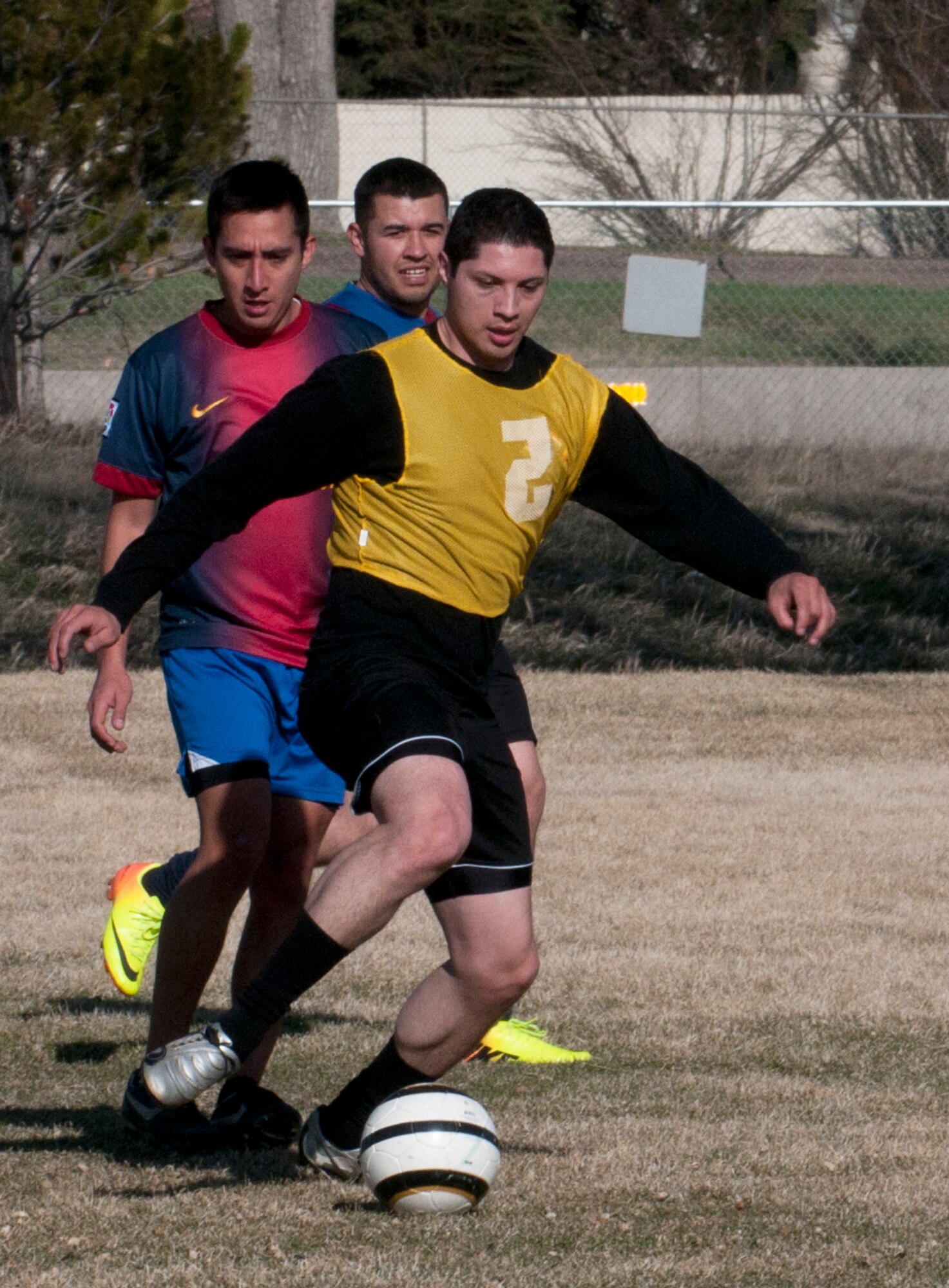 Eric Gomez, 90th Missile Security Forces Squadron, dribbles the ball away from the opposing team during the 90th Missile Wing soccer team’s practice game April 17 in the fields near the Freedom Hall Fitness Center. (U.S. Air Force photo by Airman Malcolm Mayfield)