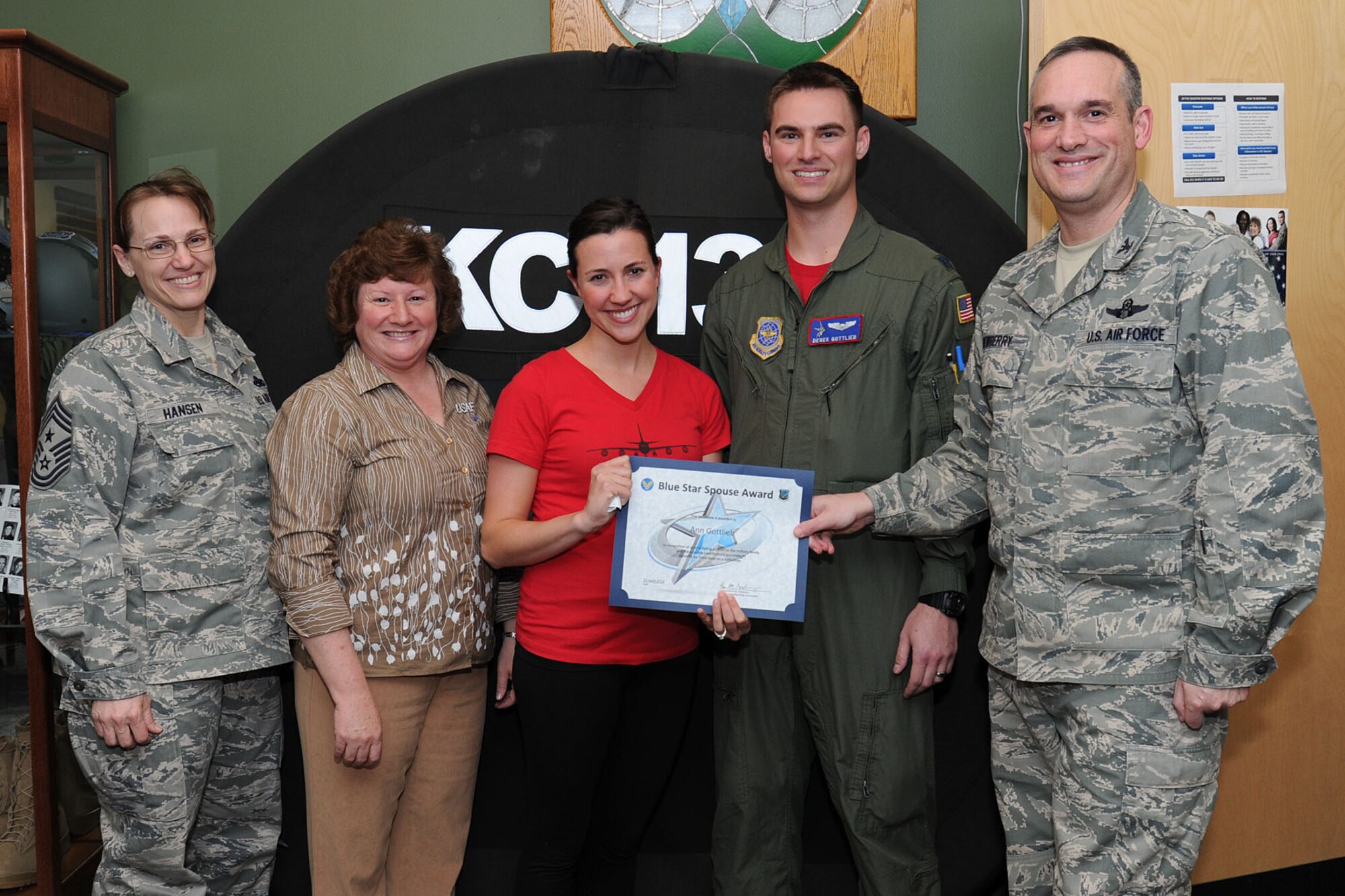 Col. Brian Newberry, the 92nd Air Refueling Wing commander, his wife, Jill, Chief Master Sgt. Wendy Hansen, the 92nd ARW command chief, present the Blue Star Spouse Award to Ann Gottlieb, spouse of Capt. Derek Gottlieb, 93rd Air Refueling Squadron, at Fairchild Air Force Base, Wash., April 25, 2014. Ms. Gottlieb went above and beyond providing amazing hospitality and support to 93rd ARS families for the last three years and dedicating countless hours as liaison to the thrift shop and volunteering in several key officer positions for the service organization, the Officer Spouses' Club. Anyone interested in nominating someone for the Blue Star Spouse Award should contact their squadron commander. (U.S. Air Force photo by Airman 1st Class Janelle Patiño/Released)