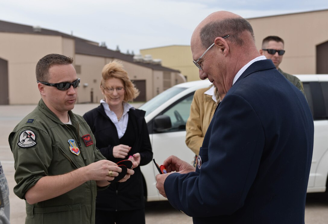 Capt. Eric Bruton, 34th Bomb Squadron B-1 pilot, presents unit patches to James Bower, son of Doolittle Raider Col. Bill Bower, during a tour on the flightline at Ellsworth Air Force Base, S.D., April 18, 2014. Bower was part of a select group that joined Ellsworth leaders for a special ceremony to commemorate the 72nd anniversary of the historic Doolittle Raid on Japan. (U.S. Air Force photo by Senior Airman Zachary Hada/Released)