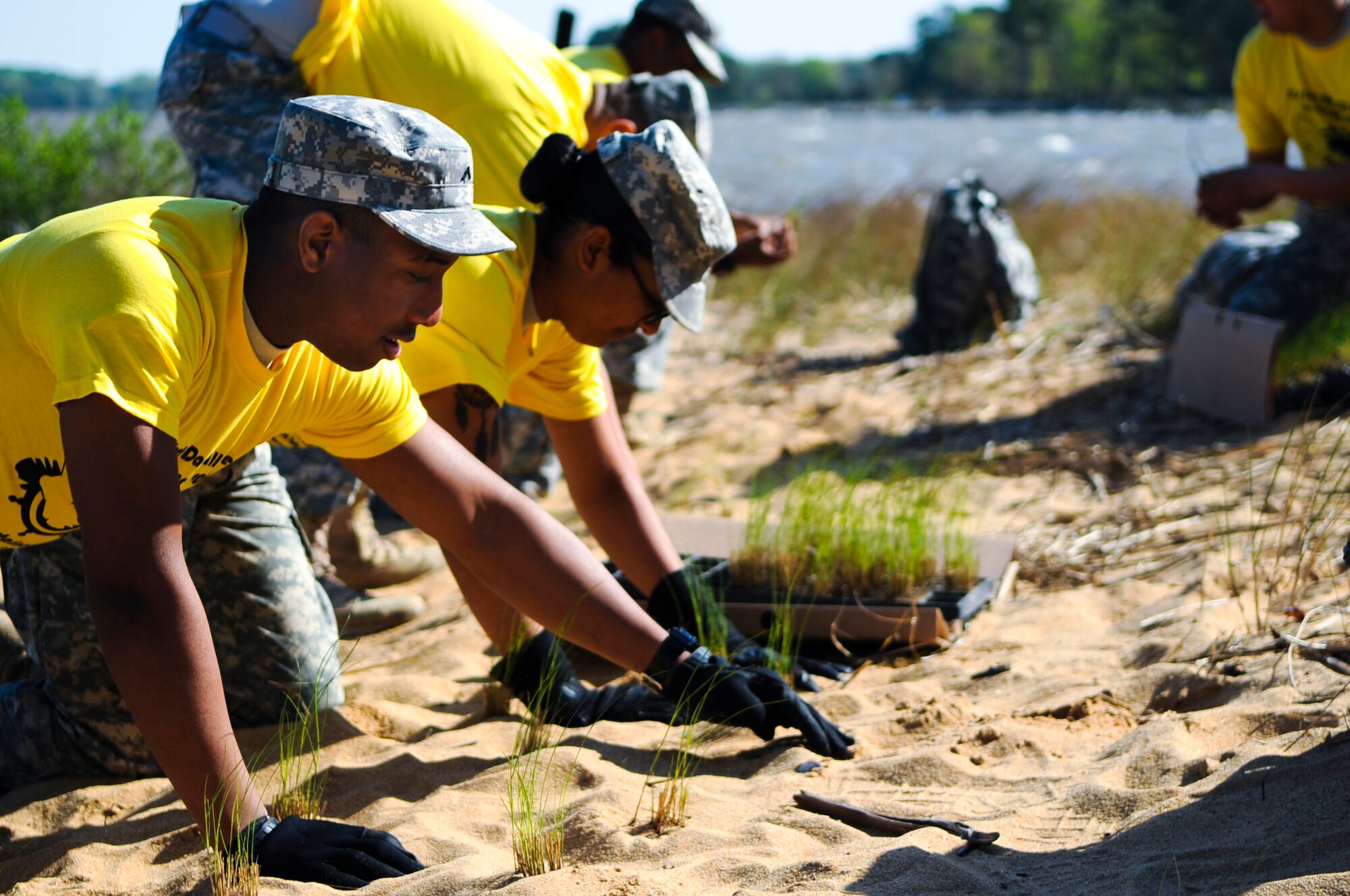 U.S. Army Soldiers plant grass during a shoreline planting activity at Fort Eustis, Va., April 23, 2014. Erosion prevention activities like shoreline foliage planting protect active training areas, which saves money in repairs for the Army. (U.S. Air Force photo by Senior Airman Austin Harvill/Released) 