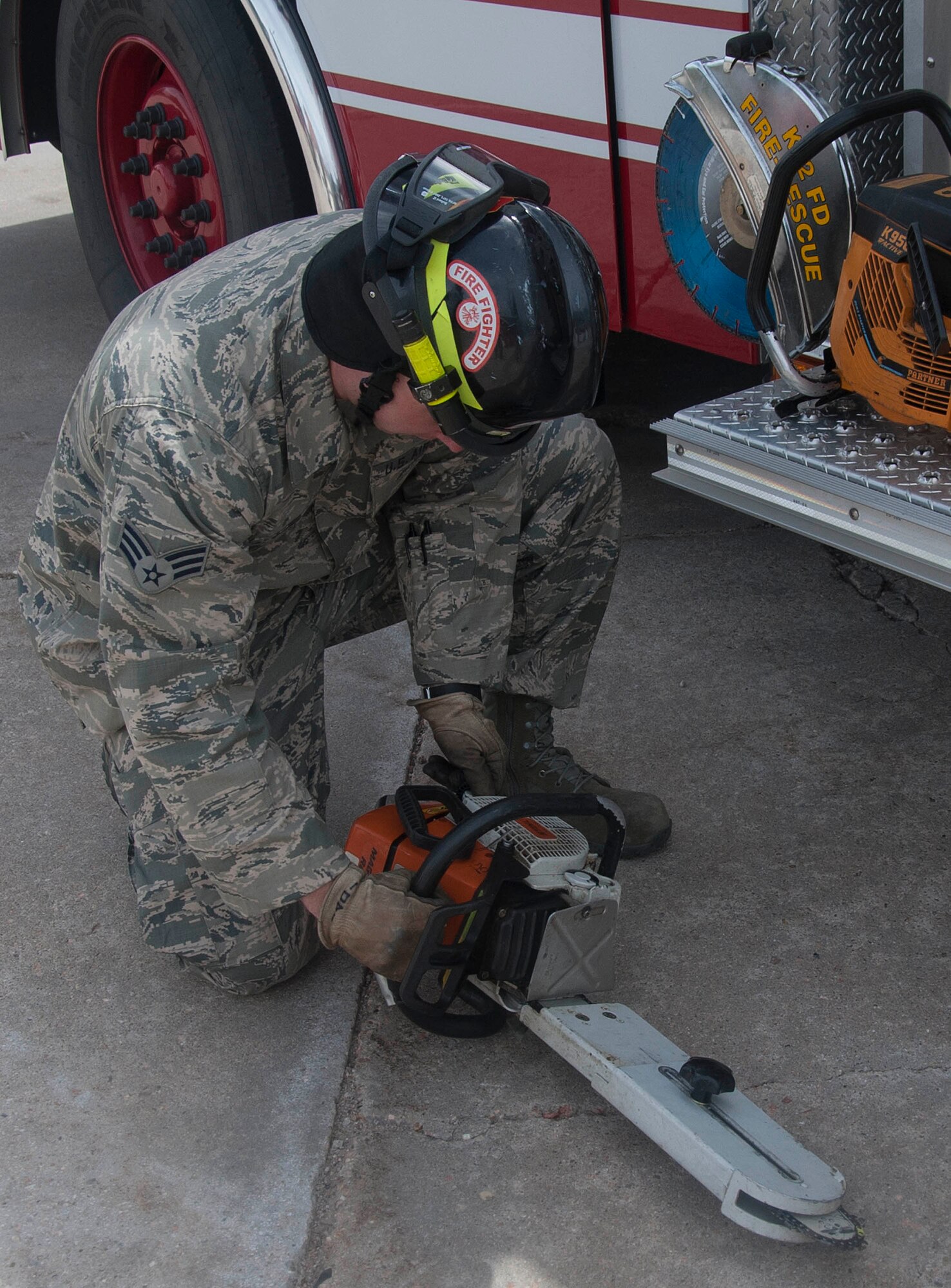 140428-F-GZ967-017 Senior Airman Sean O’Daniel, 90th Civil Engineer Squadron firefighter, inspects a chainsaw before placing it back into the truck April 28. Making sure each piece of gear is in working condition is just one task firefighters accomplish on a daily basis. (U.S. Air Force photo by Airman 1st Class Brandon Valle)