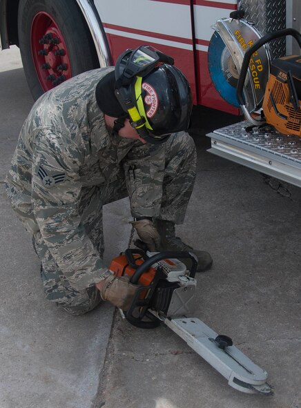 140428-F-GZ967-017 Senior Airman Sean O’Daniel, 90th Civil Engineer Squadron firefighter, inspects a chainsaw before placing it back into the truck April 28. Making sure each piece of gear is in working condition is just one task firefighters accomplish on a daily basis. (U.S. Air Force photo by Airman 1st Class Brandon Valle)