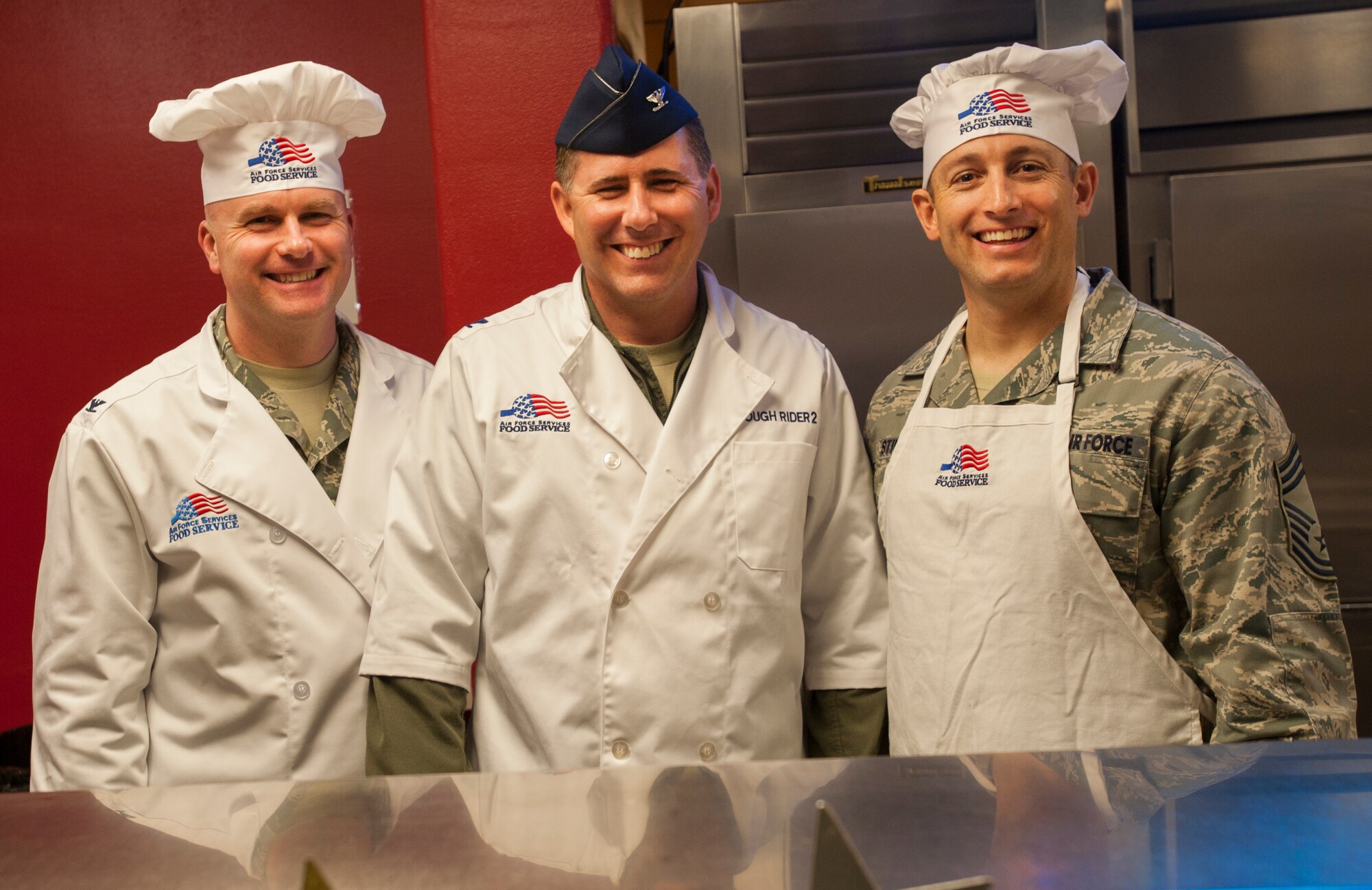 Col. Jeffrey Neischel, 5th Bomb Wing vice commander, Col. Thomas Rudy, 91st Missile Wing vice commander, and Chief Master Sgt. Thomas Stiles, 5th Medical Group superintendent, pose for a photo during the Airmen Appreciation Meal at Minot Air Force Base, N.D., April 24, 2014. The Hollywood-themed meal featured steak, lobster and a clapperboard cake. Airmen Appreciation meals are held quarterly as a way to boost morale. (U.S. Air Force photo/Airman 1st Class Apryl Hall)