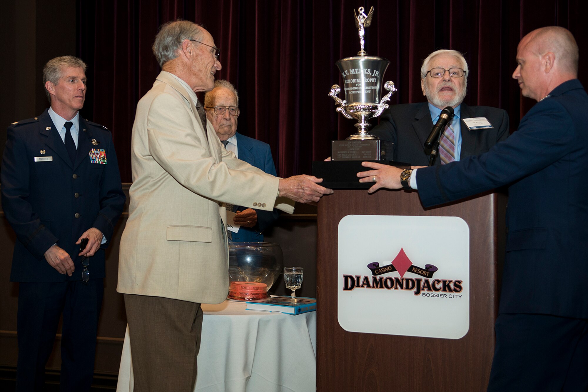 Larry Boggess, the 307th Bomb Wing B-47/KC-97 Association secretary, presents the N.V. Meeks, Jr. Memorial Trophy to U.S. Air Force Col. Jonathan Ellis, 307th Bomb Wing commander, during a reunion dinner, April 26, 2014, Bossier City, La. The trophy was created in 1963 in honor of Maj. Meeks, who was a B-47 bomber pilot killed when the jet he was flying caught fire and he was unable to eject, but kept it under control long enough for the remaining crew to safely get out of the doomed aircraft and steer the jet to an unpopulated area before impacting the ground. (U.S. Air Force photo by Master Sgt. Greg Steele/Released)