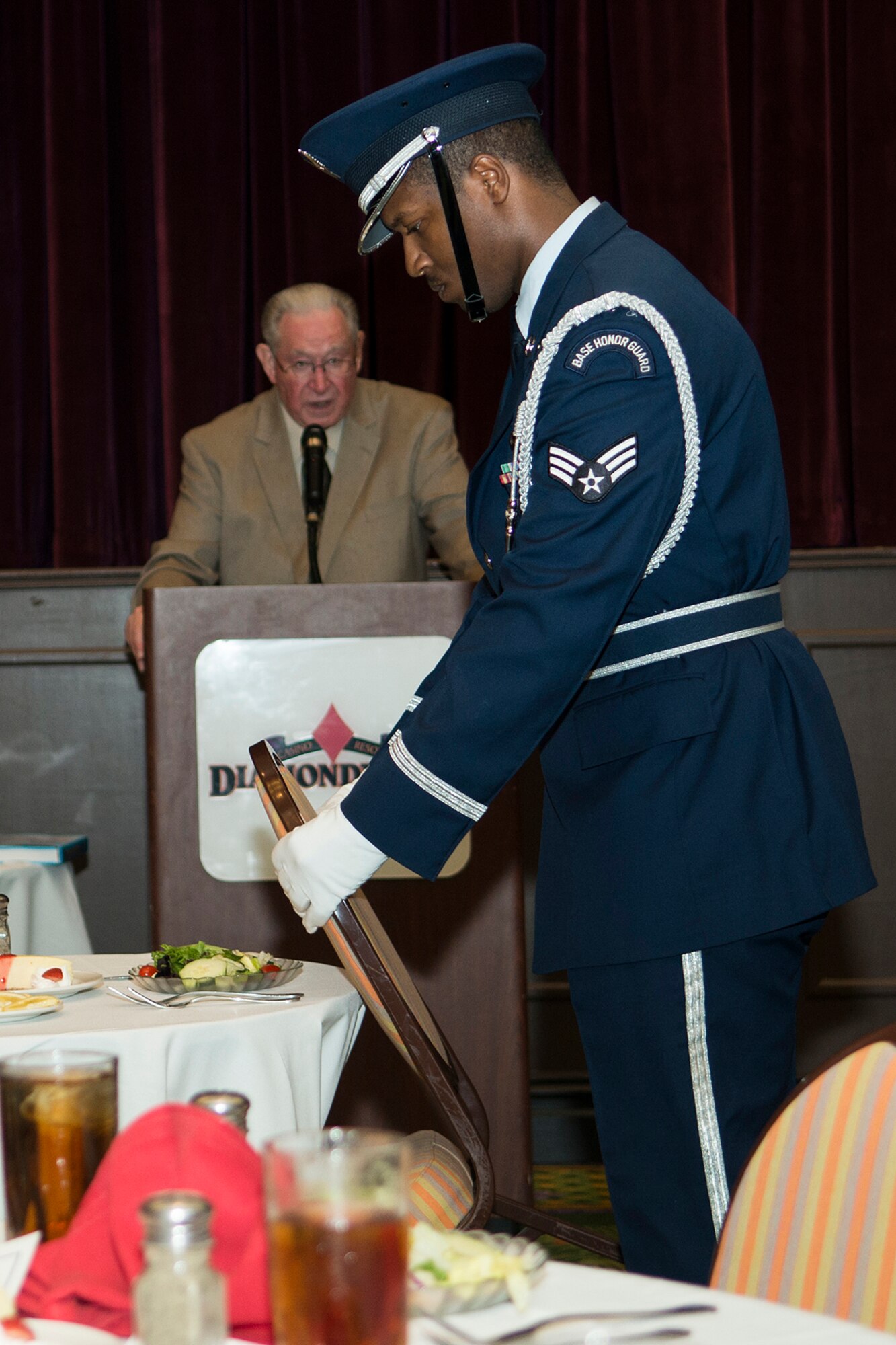 A member of the Barksdale Base Honor Guard places an empty chair next to a table as part of the Prisoners of War/Missing in Action table ceremony held during the 307th Bomb Wing Combined Bomber/Tanker Reunion, April 26, 2014, Bossier City, La. The ceremony is held to honor military service members who fought in past or present wars and remain unaccounted for. (U.S. Air Force photo by Master Sgt. Greg Steele/Released)