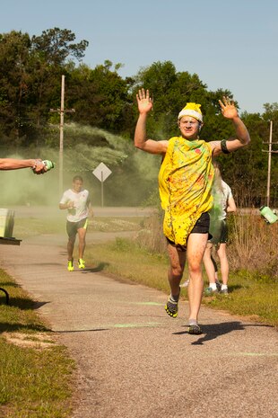 Petty Officer 3rd Class Stefan Andrade, a student with the Naval Nuclear Power Training Command, runs through the green color station followed closely by Petty Officer 3rd Class Aendel Mendoza during the 5k color run held at Joint Base Charleston, S.C., April, 26, 2014. Andrade was the first male to finish the race with a time of 18:50, with Mendoza finishing shortly behind him at 18:57. (U.S. Air Force photo/Staff Sgt. Renae Pittman)