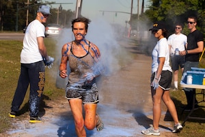 Ensign Jennifer Oblinger, a staff member with the Naval Nuclear Power Training Command, runs through the blue color station during the 5k color run held at Joint Base Charleston, S.C., April, 26, 2014. Oblinger was the first female to finish the race with a time of 20:57. (U.S. Air Force photo/Staff Sgt. Renae Pittman)