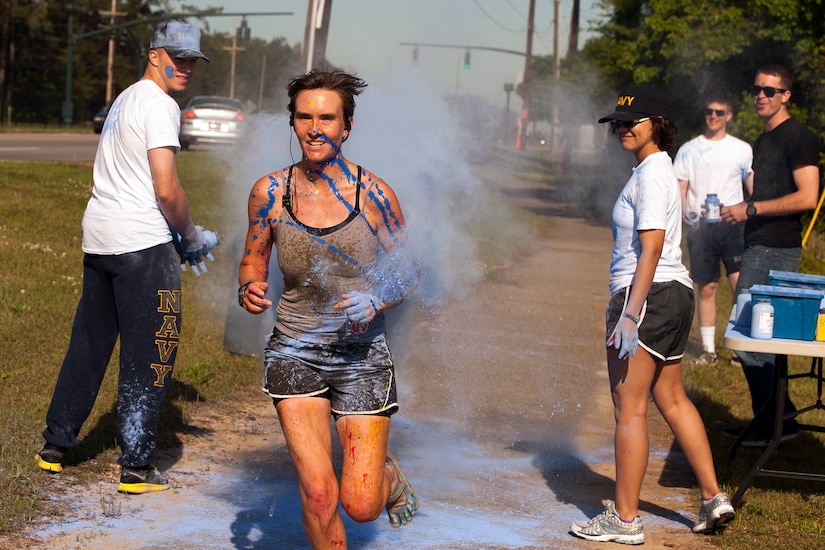Ensign Jennifer Oblinger, a staff member with the Naval Nuclear Power Training Command, runs through the blue color station during the 5k color run held at Joint Base Charleston, S.C., April, 26, 2014. Oblinger was the first female to finish the race with a time of 20:57. (U.S. Air Force photo/Staff Sgt. Renae Pittman)