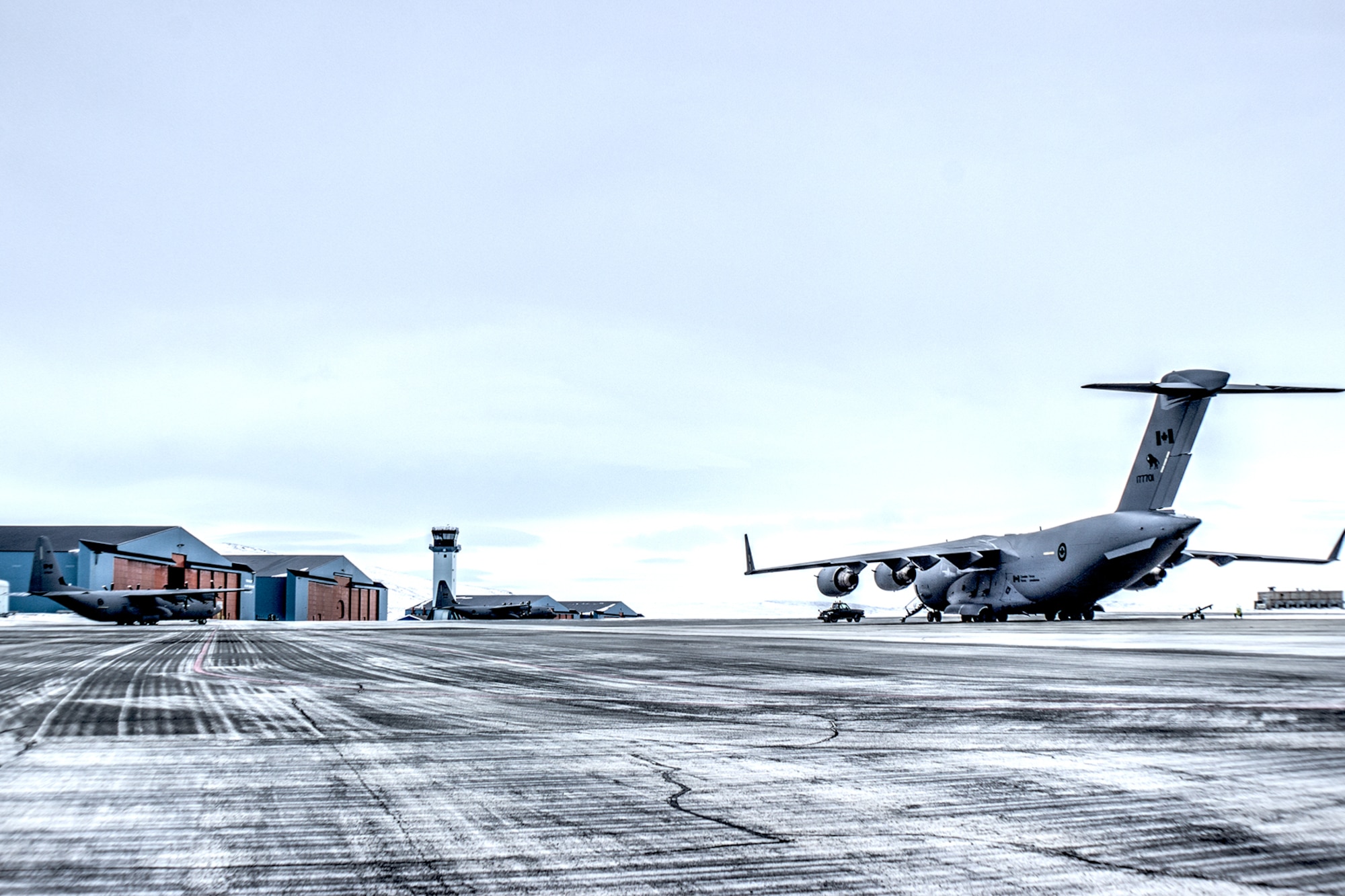 THULE AIR BASE, Greenland – A Royal Canadian Air Force C-17 Globemaster III and two C-130J Super Hercules aircraft from the 8th Wing Canadian Forces Base out of Trenton, Canada, are parked on the ramp at Thule Air Base April 25. The aircraft are set to carry cargo to resupply Canadian Forces Station Alert with fuel and other supplies to get them through the harsh Arctic winter. (U.S. Air Force photo/Tech. Sgt. David Buchanan)