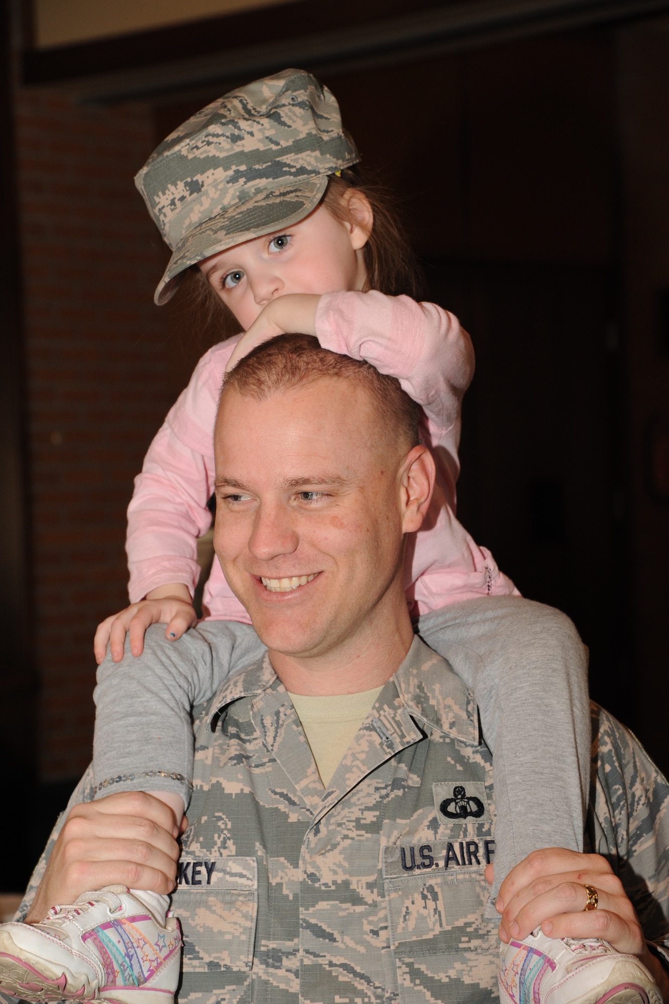 Master Sgt. Jason Trickey, the Radar Approach Control chief controller, carries his daughter Lilia on his shoulders during Vance’s Annual Spring Fling held in the club April 8. During Spring Fling, vendors from the local community and representatives from different services on base set up booths to talk with attendees about the services they offer. This year, attendees enjoyed free sloppy joes during the event. (U.S. Air Force photo/Senior Airman Frank Casciotta)
