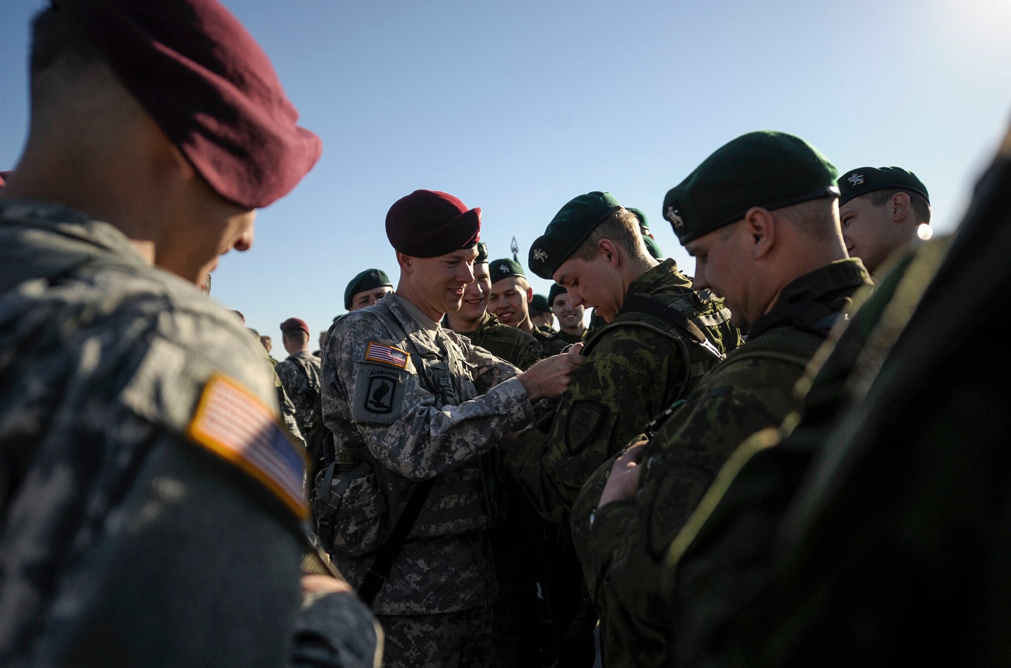 A paratrooper from the 173rd Infantry Brigade Combat Team (Airborne) trades unit patches with a soldier from the Lithuanian Army April 26, 2014 at Siauliai air base, Lithuania. Airmen from the 37th Airlift Squadron transported 150 paratroopers from Aviano Air Base, Italy to Lithuania at the request of the host nations in the region and to further demonstrate U.S. commitment to NATO. (U.S. Air Force photo/Staff Sgt. Sara Keller)