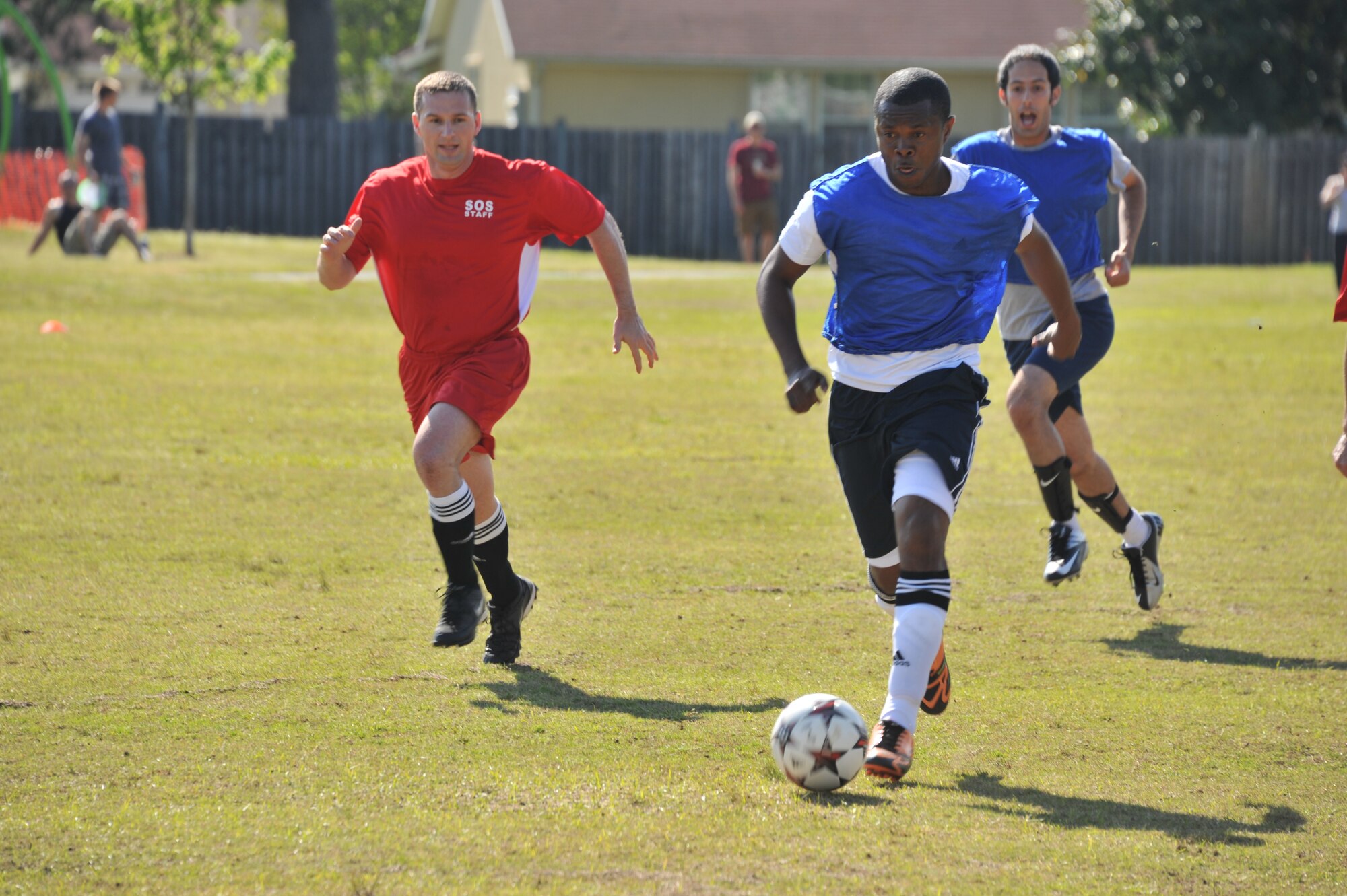 Capt. Frank Ato Mills, Squadron Officer School international officer student from Ghana, runs the ball down the soccer pitch toward the opposing team’s goal while Maj. Ed Talley, SOS instructor, tries to intercept the ball during a soccer match between the International Officers School and the Squadron Officer College on Maxwell April 21, 2014. The match is designed to fulfill the Air University’s mission goal of building partnerships between international defense partners and the U.S. (U.S. Air Force photo by Staff Sgt. Gregory Brook)