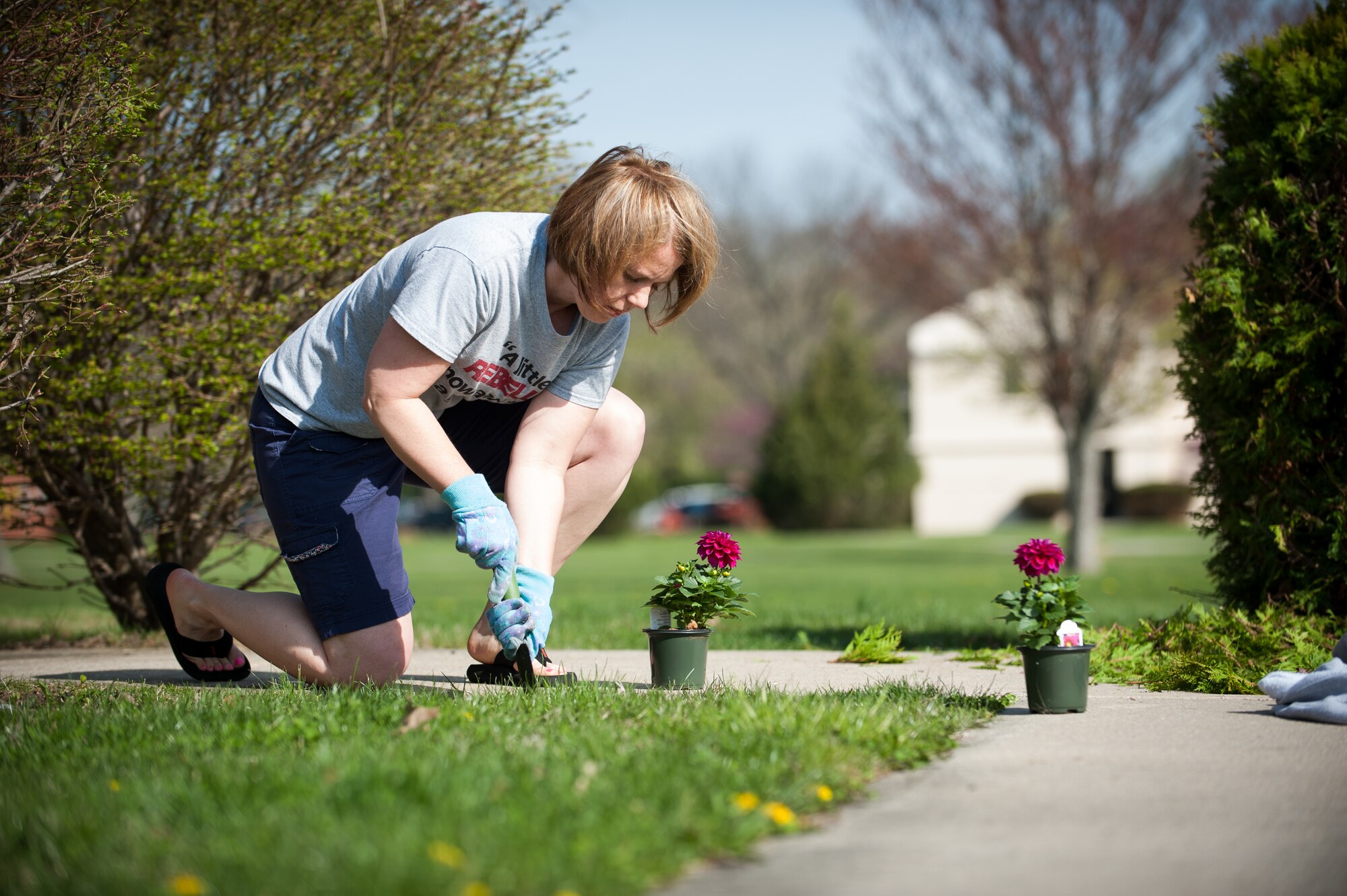 Tech Sgt. Denise Gambs, 87th Air Base Wing Area Defense Council defense paralegal, plants flowers at building 2906 during Joint Base Beautification Day Apr. 22, 2014, at Joint Base McGuire-Dix-Lakehurst, N.J. The spring clean up gave units the opportunity to show pride in JB MDL's appearance. Gambs hails from Red Oak, Iowa. (U.S. Air Force photo by Russ Meseroll/Released)