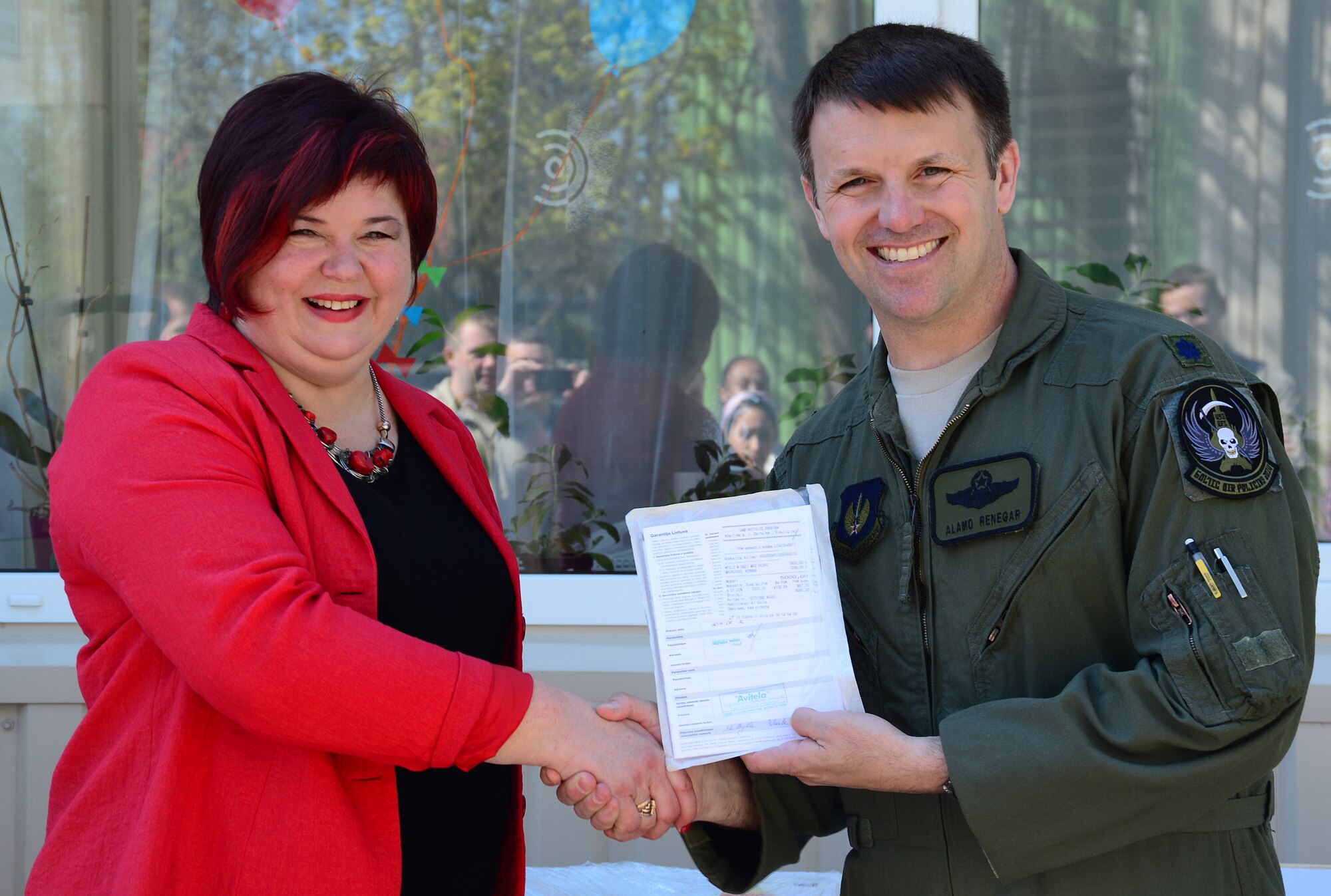 Lt. Col. Lendy Renegar, 48th Air Expeditionary Group commander, gives Audronė Kardašienė, the director of the Šiauliai City Baby’s Orphanage in Lithuania, the owner’s manual to a brand new industrial washer and dryer April 27, 2014. Airmen from the 48th AEG raised money throughout the four month Baltic Air Policing mission to buy the washer and dryer to give to the orphanage. The Airmen also visited the orphanage multiple times during their deployment. (U.S. Air Force photo by Airman 1st Class Dana J. Butler/Released)
