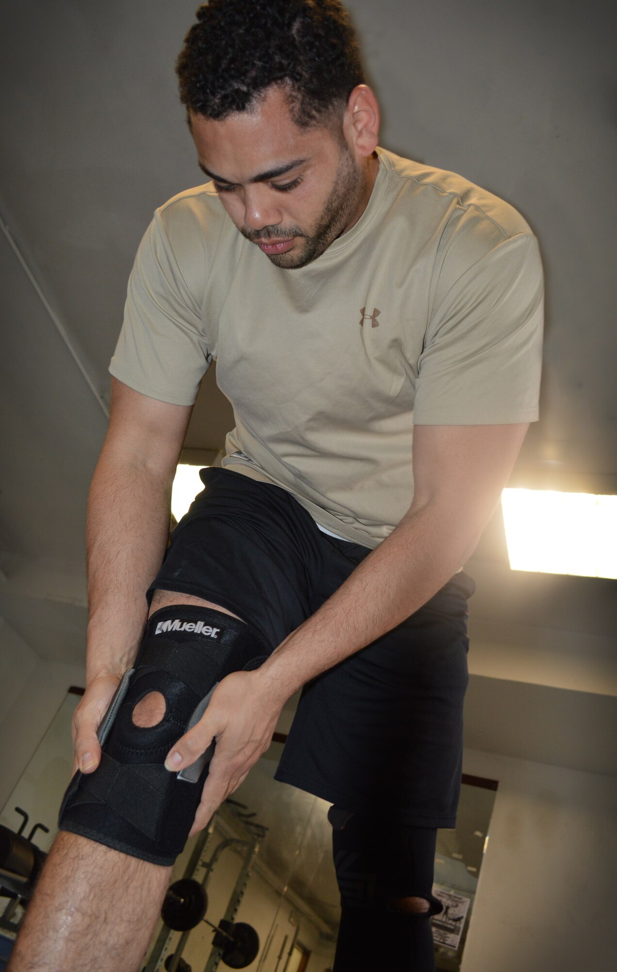 Staff Sgt. Steven Acevedo, 31st Maintenance Group unit fitness program manager, puts on a knee brace at the Falcon Fitness Center, April 21, 2014, at Aviano Air Base, Italy.  The Health and Wellness Center offers physical therapy as a tool to recovery after a surgery or injury. (U.S. Air Force photo/Airman First Class Abbey Whittaker)