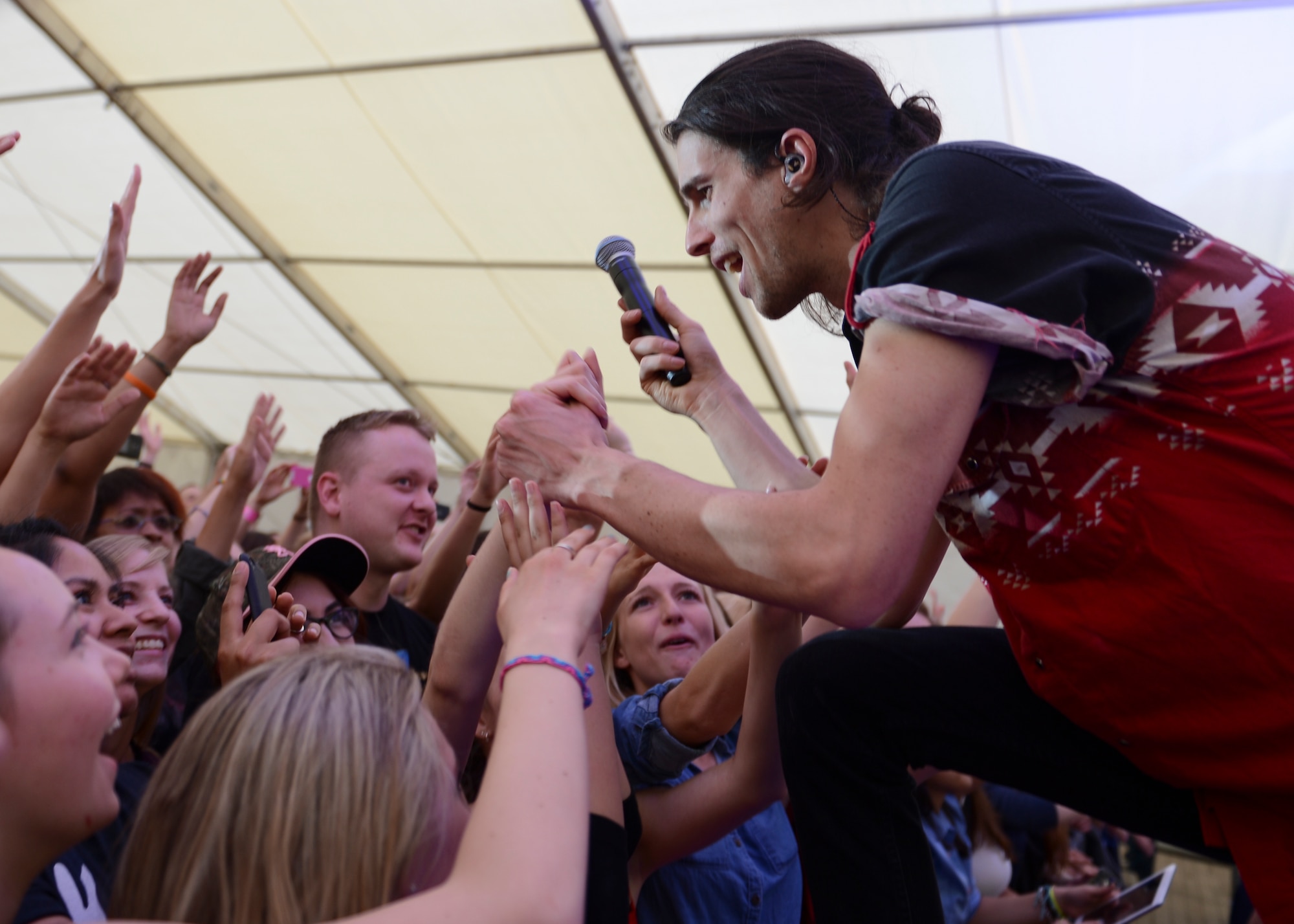 Nathaniel Motte, American musician, shakes hands with his fans during a free concert hosted by Armed Forces Entertainment April 25th, 2014, at Ramstein Air Base Germany. Motte is a part of 3OH!3, an American electronic musical duo from Boulder, Colorado. After the show, the duo stuck around to sign autographs and take pictures with their fans. (U.S. Air Force Photo/Airman 1st Class Michael Stuart)