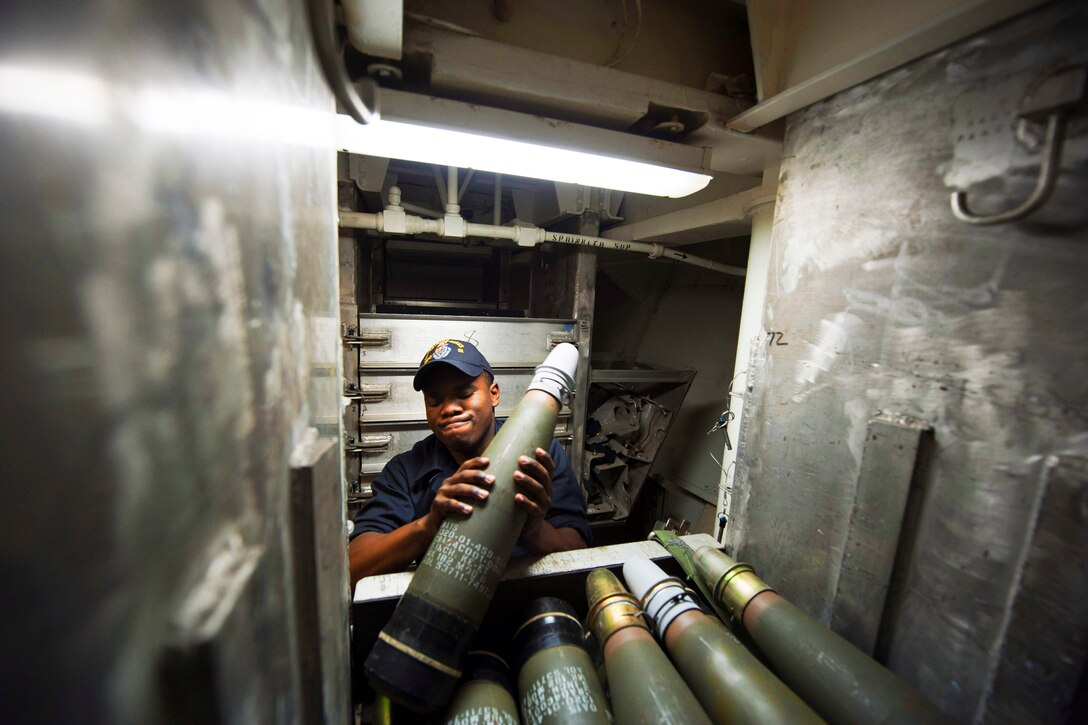 U.S. Navy Seaman Desmond Summers takes out a round from an ammunition bin for the Mk 45 5-inch lightweight gun aboard the guided-missile destroyer USS Arleigh Burke in the Atlantic Ocean, Feb. 26, 2014. The Burke is supporting maritime security operations and theater security cooperation efforts in the U.S. 5th and 6th Fleet area of operations. 