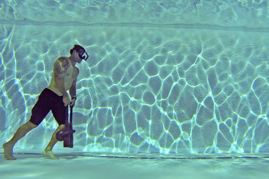 Navy Petty Officer 3rd Class Paul Osis performs underwater kettlebell walks to increase lung power and endurance at Scott Pool on Joint Base Pearl Harbor-Hickam, Hawaii, Feb. 27, 2014. Osis is a search and rescue swimmer assigned to the USS O'Kane. 