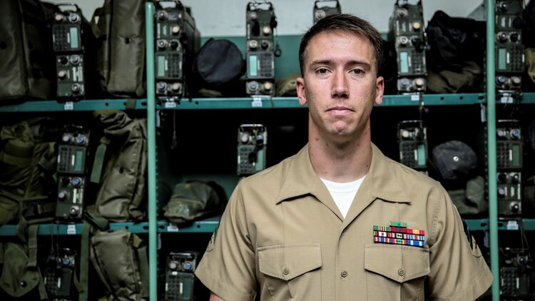 Sergeant Kristopher Golden, radio chief, 15th Marine Expeditionary Unit, poses for a photo in front of gear he is responsible for aboard Camp Pendleton, Calif., April 25, 2014. Golden, 27, is from Lacey, Wash.