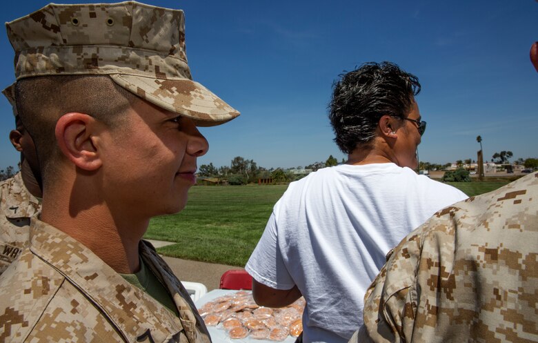 Pfc. Hector Mantano, an administrative clerk with the Installation Personnel Administrative Center, waits in line at a Sexual Assault Prevention and Response booth for information and pamphlets after the fifth annual Sexual Assault Awareness Month Walk aboard Marine Corps Air Station Miramar, Calif., April 29. Participants had the chance to learn more about programs offered to survivors of sexual assaults after the walk.
