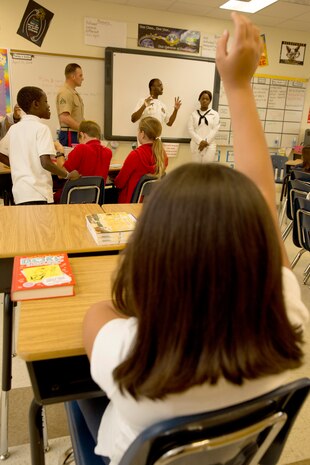 Isabella Navarro, fourth grader of Harbordale Elementary School in Fort Lauderdale, Fla., raises her hand to ask a question to Cpl. Joel A. Slaymaker, native of Lancaster, Penn., and amphibious assault crewman with 2nd Assault Amphibian Battalion, 2nd Marine Division, Marine Corps Base Camp Lejeune, N.C., Senior Chief Jerald D. Baker, native of Bainbridge, Ga., and operations specialist, and Seaman Shammeonia M. Benson, native of Montgomery, Ala., and culinary specialist, during a school visit to Harbordale Elementary School in Fort Lauderdale, Fla., April 30, as part of a community relations event of Fleet Week Port Everglades 2014. Three Marines from 2nd AAV Bn., and 2nd Battalion, 6th Marine Regiment, 2nd Marine Division, as well as Sailors from the USS New York (LPD 21) and Carrier Strike Group 12 spoke to more than 450 Harbordale Elementary students about their experiences in the military and on ship. (U.S. Marine Corps photo by Sgt. Alicia R. Leaders/Released)