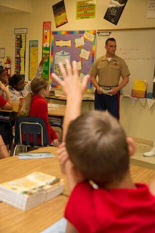 Tyler M. Nilson, fourth grader of Harbordale Elementary School in Fort Lauderdale, Fla., raises his hand to ask a question to Cpl. Joel A. Slaymaker, native of Lancaster, Penn., and amphibious assault crewman with 2nd Assault Amphibian Battalion, 2nd Marine Division, Marine Corps Base Camp Lejeune, N.C., during a school visit to Harbordale Elementary School in Fort Lauderdale, Fla., April 30, as part of a community relations event of Fleet Week Port Everglades 2014. Three Marines from 2nd AAV Bn., and 2nd Battalion, 6th Marine Regiment, 2nd Marine Division, as well as Sailors from the USS New York (LPD 21) and Carrier Strike Group 12 spoke to more than 450 Harbordale Elementary students about their experiences in the military and on ship. (U.S. Marine Corps photo by Sgt. Alicia R. Leaders/Released)