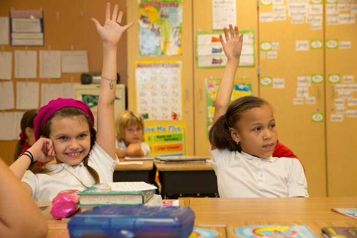 (From left) Michaela Z. Lovejoy, and Cameron L. Houston, both second graders of Harbordale Elementary School in Fort Lauderdale, Fla.,raise their hands to ask Marines and Sailors questions furing a school visit to Harbordale Elementary School in Fort Lauderdale, Fla., April 30, as part of a community relations event of Fleet Week Port Everglades 2014. Three Marines from 2nd Assault Amphibian Battalion, and 2nd Battalion, 6th Marine Regiment, 2nd Marine Division, as well as Sailors from the USS New York (LPD 21) and Carrier Strike Group 12 spoke to more than 450 Harbordale Elementary students about their experiences in the military and on ship. (U.S. Marine Corps photo by Sgt. Alicia R. Leaders/Released)
