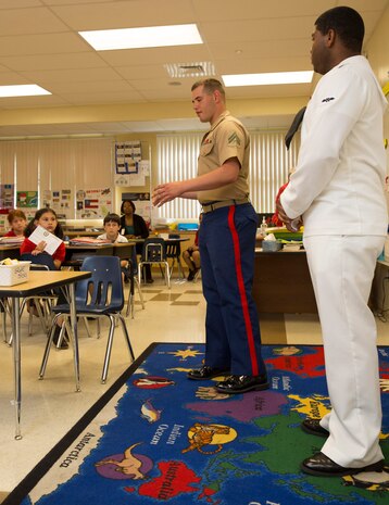 Cpl. Brandon M. Carteaux, native of Dallas, Ga., and amphibious assault crew chief with 2nd Assault Amphibian Battalion, 2nd Marine Division, Marine Corps Base Camp Lejeune, N.C., and Airman Apprentice Daniel Goodridge, native of Brooklyn, N.Y., and aviation boatswains mate (fueling), talk to second-grade students during a school visit to Harbordale Elementary School in Fort Lauderdale, Fla., April 30, as part of a community relations event of Fleet Week Port Everglades 2014. Three Marines from 2nd AAV Bn., and 2nd Battalion, 6th Marine Regiment, 2nd Marine Division, as well as Sailors from the USS New York (LPD 21) and Carrier Strike Group 12 spoke to more than 450 Harbordale Elementary students about their experiences in the military and on ship. (U.S. Marine Corps photo by Sgt. Alicia R. Leaders/Released)