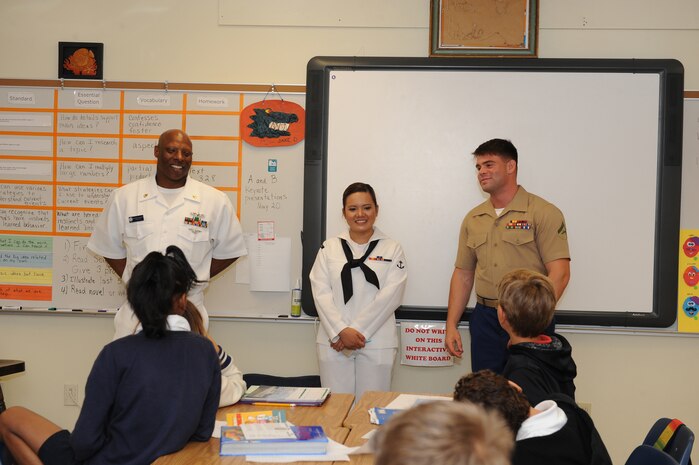(From left) Chief Wayne Richardson from the USS New York (LPD 21), Seaman Apprentice Justine Ivanitskiy from USS New York (LPD 21) and Lance Cpl. Bryan Whitworth from the 2nd Battalion, 6th Marine Regiment, 2nd Marine Division, Marine Corps Base Camp Lejeune, N.C., visit children at Harbordale Elementary School as part of Fleet Week Port Everglades 2014.This is the 24th annual Fleet Week in Port Everglades, South Florida’s annual celebration of the maritime services. (U.S. Navy photo by Petty Officer 3rd Class Stephane Belcher/Released)