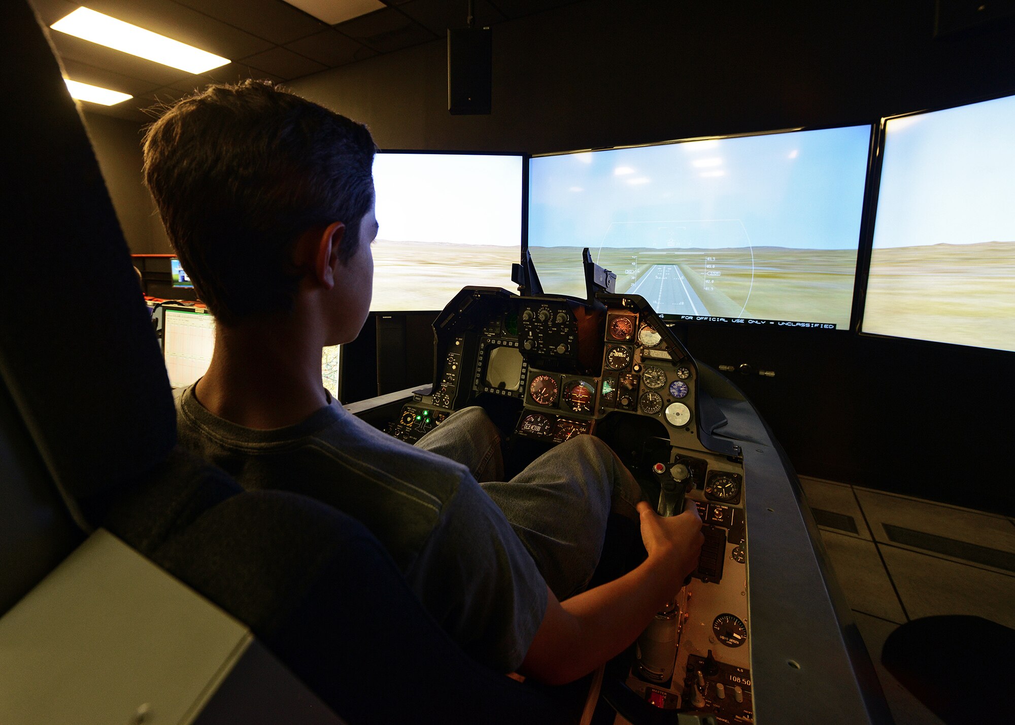 An Aero Camp student attempts to land on Runway 22 in an F-16 simulator April 24 at the Integration Facility for Avionics System Testing (IFAST) building.This year's second annual Aero Camp was held April 21 to 25, and is intended to train students, ages 14 to 19, with the help of certified flight instructors in the areas of flight and ground school training. The second camp is scheduled for late July.(U.S. Air Force photo by Jet Fabara)