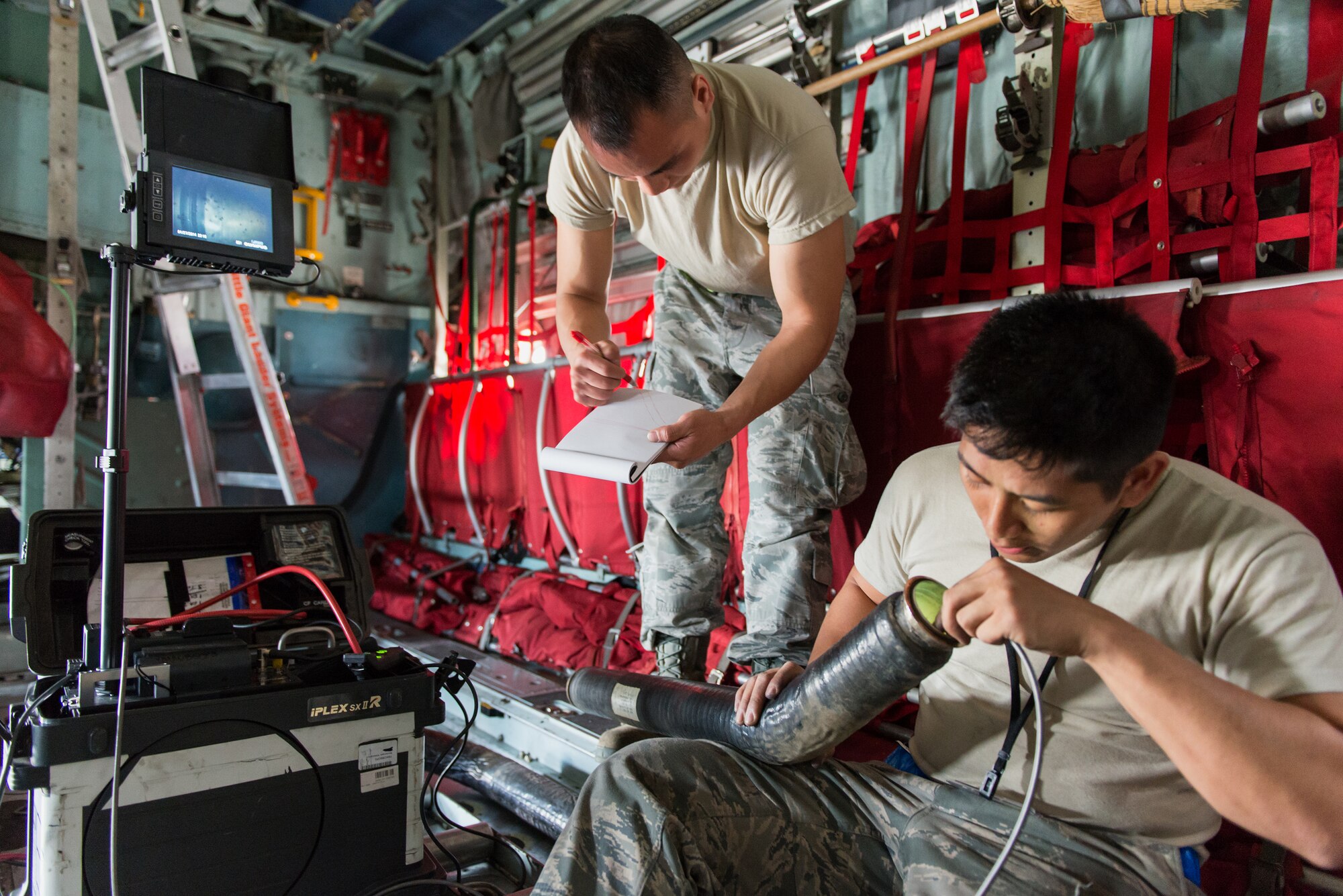 (Right to left) Airman 1st Class Alexander Buenviaje and Senior Airman Paul Nguyen, both of the 374th Aircraft Maintenance Squadron electrical and environmental shop, use a video borescope to inspect parts of a C-130 Hercules at Yokota Air Base, Japan, April 28, 2014.  Yokota maintainers spend their time troubleshooting maintenance issues on the flightline and conducting daily maintenance on the aircraft. (U.S. Air Force photo by Osakabe Yasuo/Released)